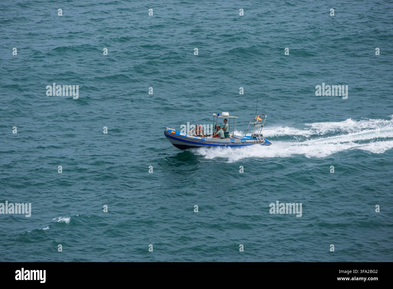 Nave di pattuglia della Guardia Civil spagnola che sfreccia lungo la costa atlantica di Gijon, Spagna Foto Stock