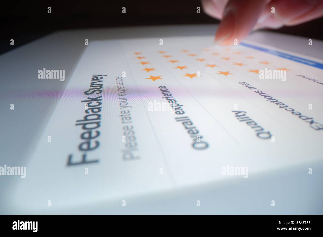 Macro di una valutazione a cinque stelle in un sondaggio di feedback del cliente su un tablet, scattato con una lente macro-probe Foto Stock