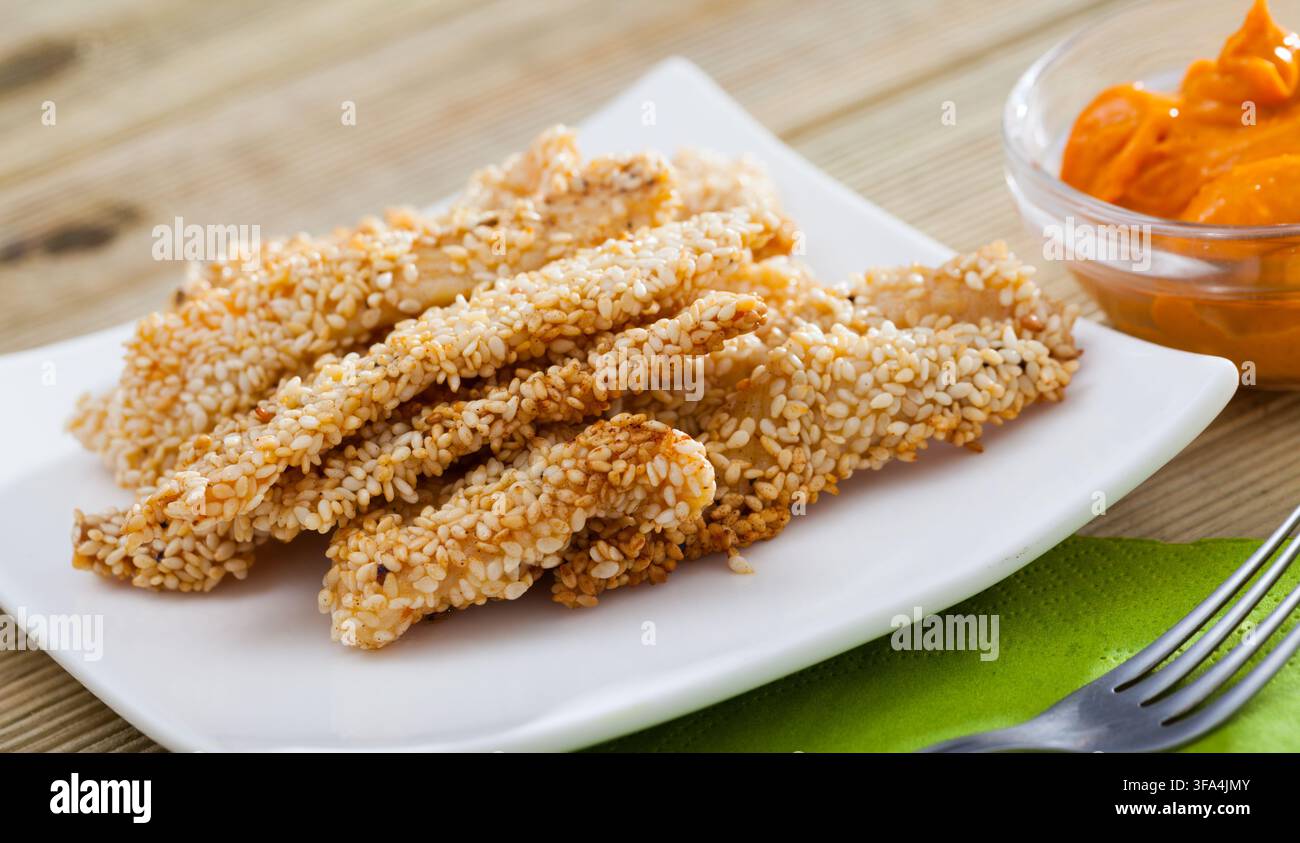 Strisce di pollo al sesamo con salsa Foto Stock