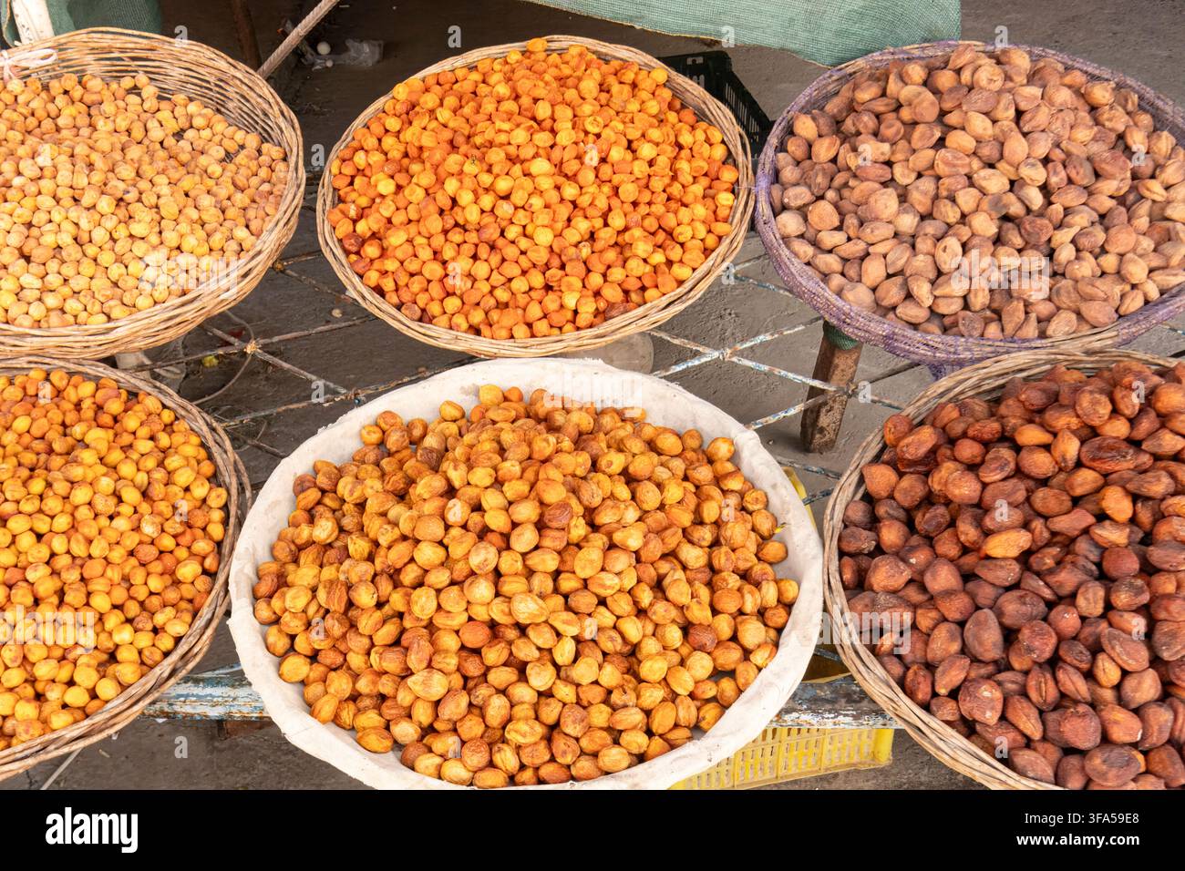 Vari tipi di frutta secca e datteri disposti in cesti di vimini tradizionali in un mercato a Samarcanda, Uzbekistan. Foto Stock