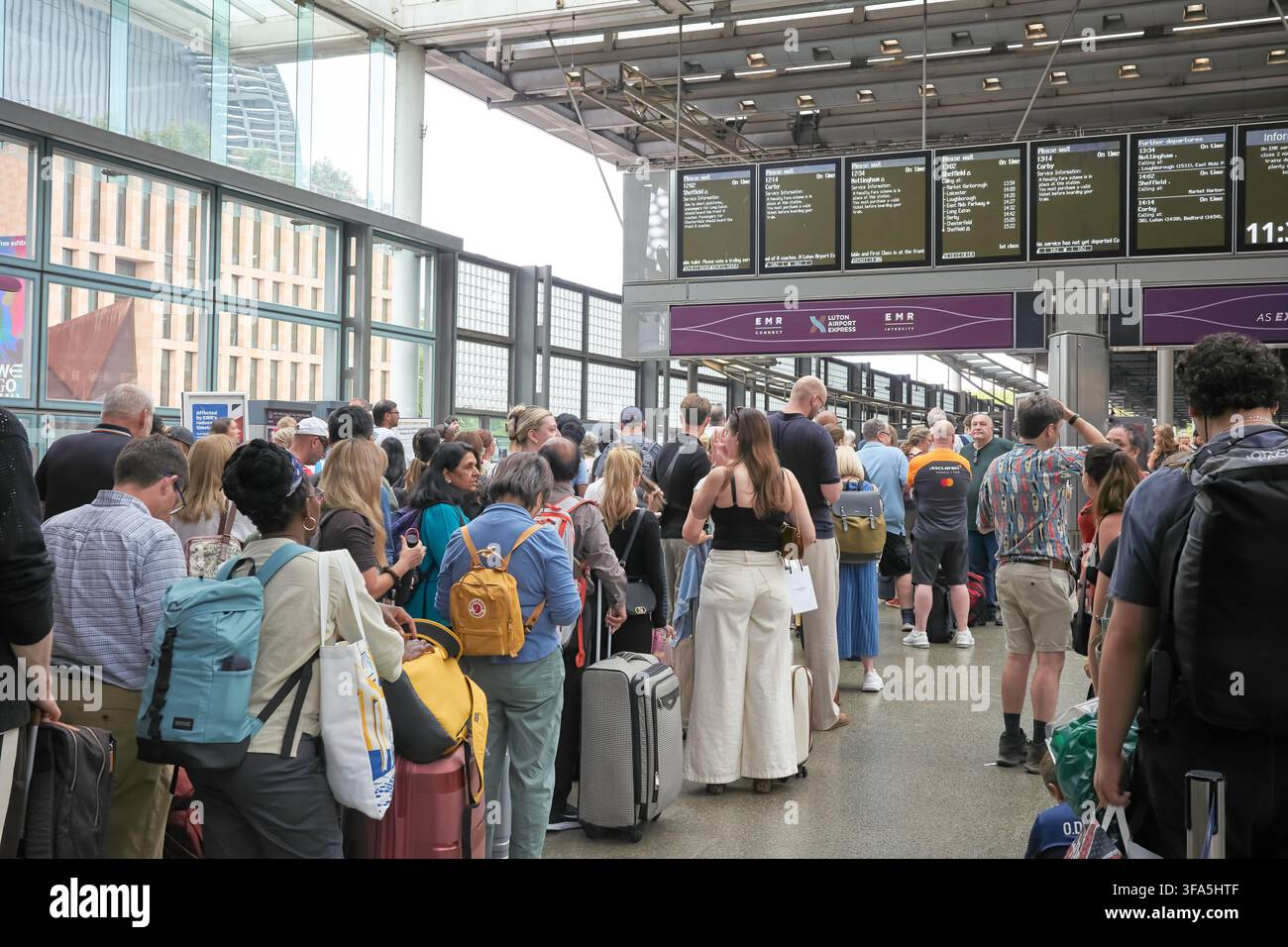 Lunga fila di passeggeri in attesa di un treno intercity EMR in ritardo alla stazione ferroviaria di St Pancras, Londra, Inghilterra. Foto Stock