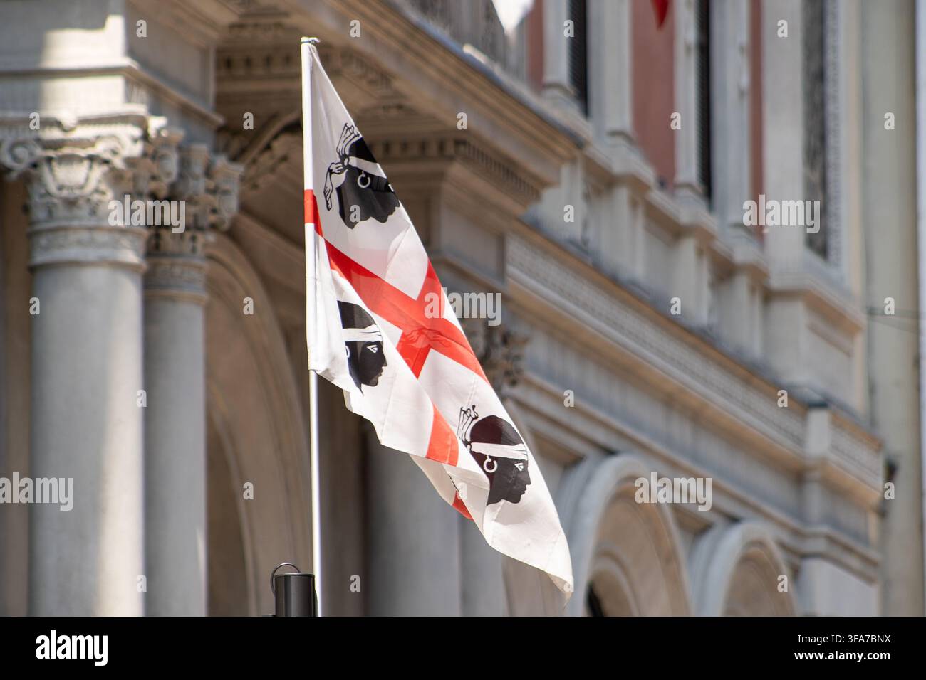 Bandiera della Sardegna con i Quattro Mori che sventola sulla facciata di un antico edificio storico. Milano, Italia Foto Stock