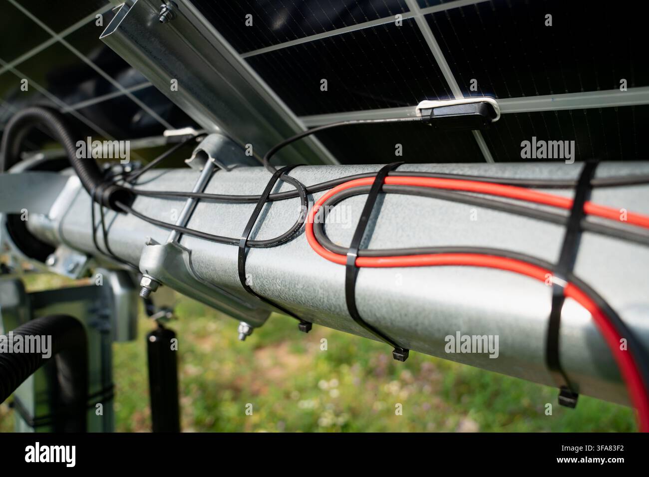 Struttura di rackaging a tubo torico in acciaio galvanizzato con cablaggio DC gestito e scatola di giunzione solare su un'installazione solare commerciale Foto Stock