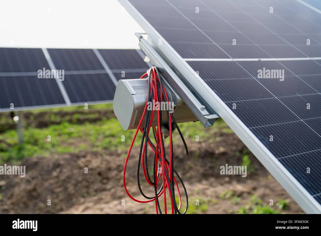 Impianto elettrico e motore di azionamento elettrico montati sul telaio di un sistema di tracciamento dei pannelli solari durante la costruzione di una fattoria solare Foto Stock