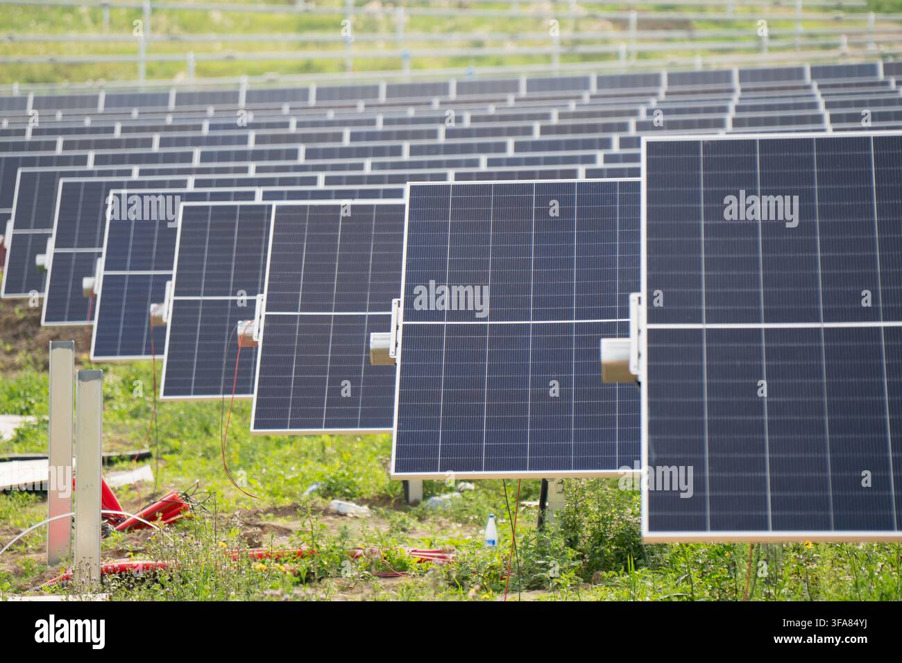 Moduli di pannelli solari monocristallini montati su inseguitori ad asse singolo motorizzati in un campo di centrale fotovoltaica Foto Stock