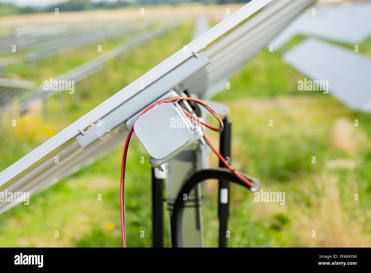 Scatola di connessione posteriore di un modulo solare fotovoltaico con cablaggio installato su un sistema di tracciamento a singolo asse in un parco solare Foto Stock