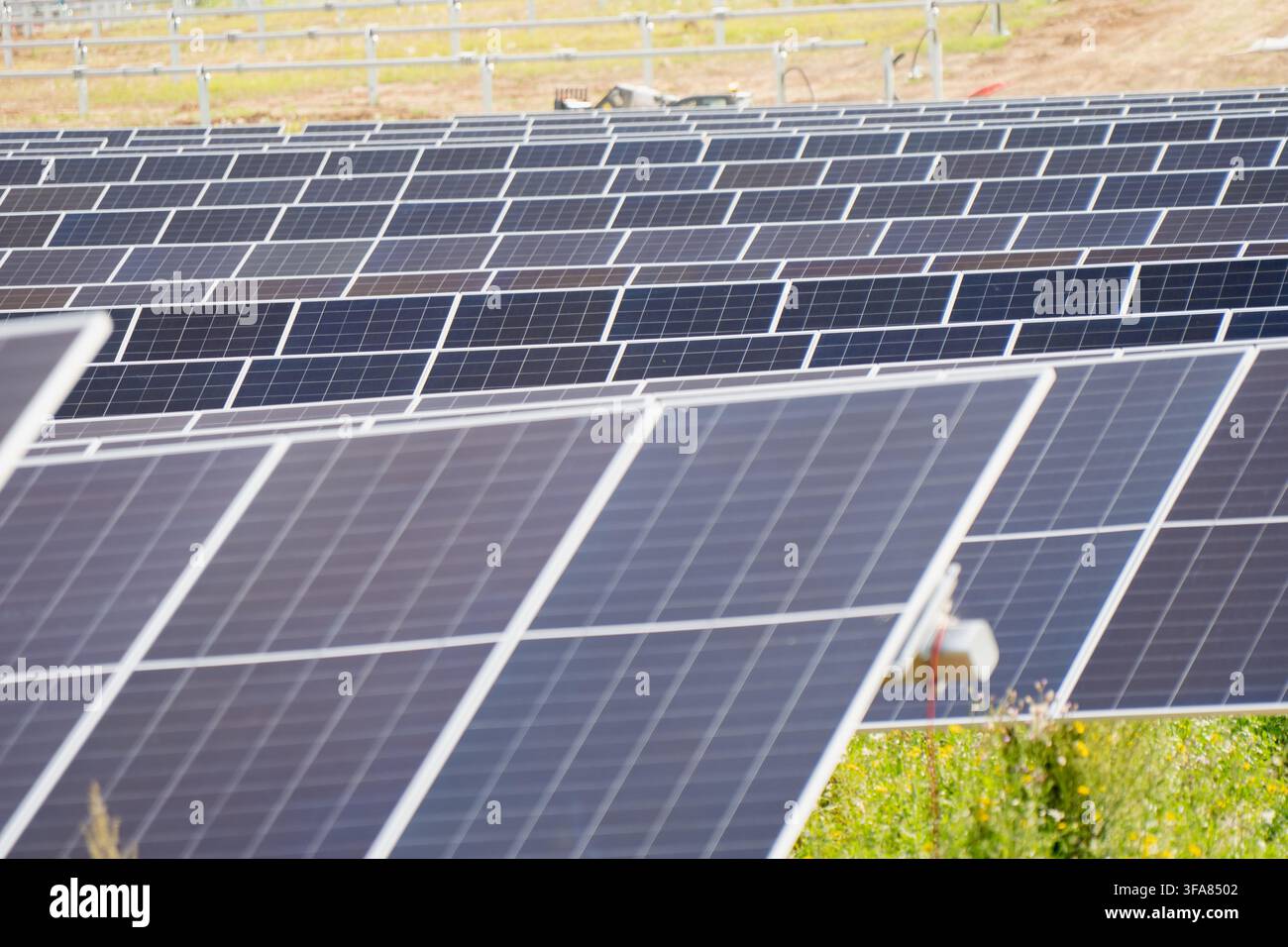 Moduli di pannelli solari monocristallini montati su un sistema di tracciamento ad asse singolo in una centrale fotovoltaica su scala industriale Foto Stock