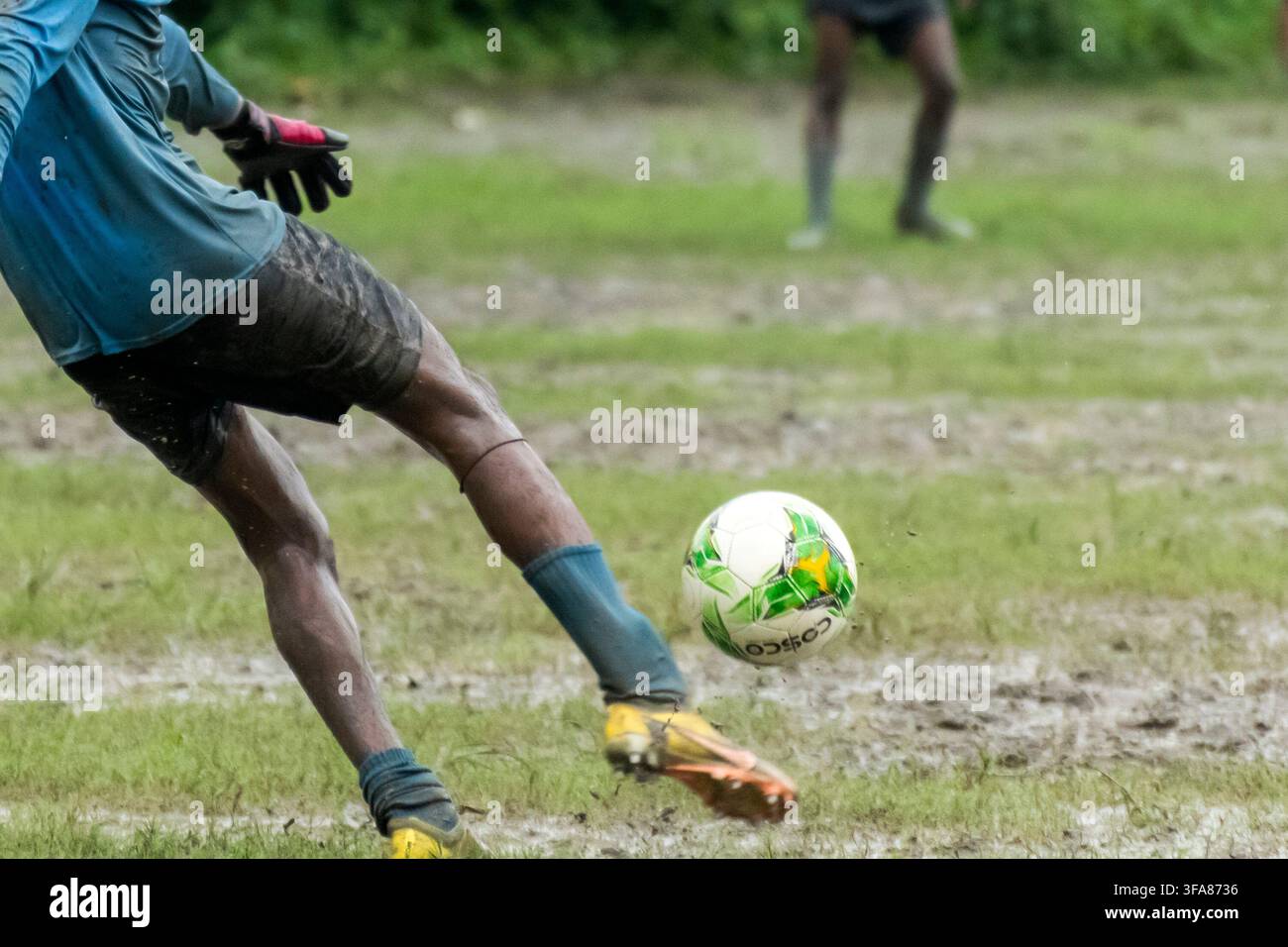 Portiere di calcio che corre per calciare il pallone da calcio Foto Stock