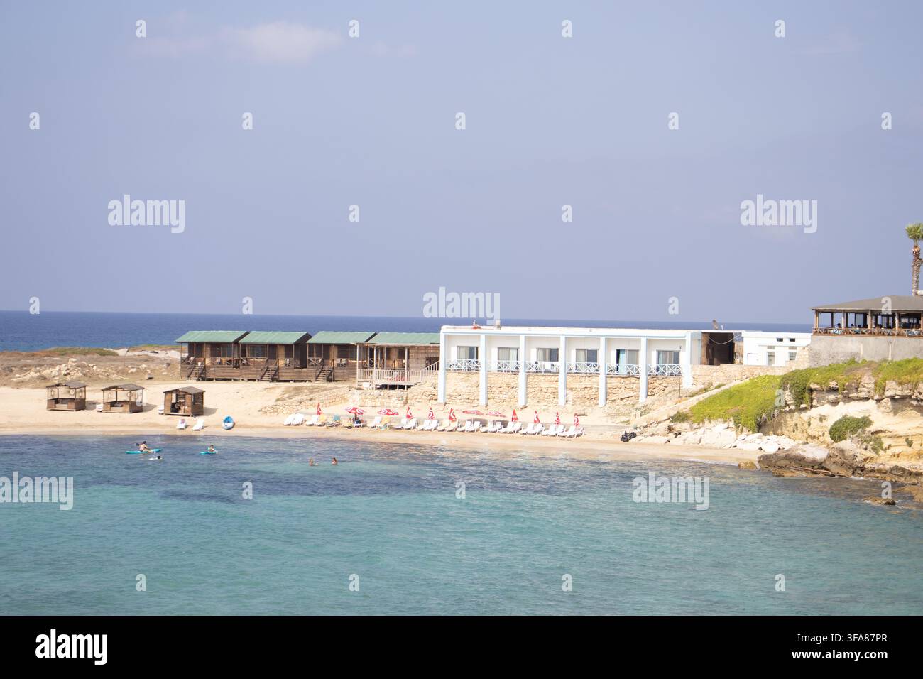 Hotel e ristorante Oasis sulla spiaggia di Ayfilon. Dipkarpaz. Vista costiera sulle rovine storiche in pietra, resort sul lungomare. Foto Stock
