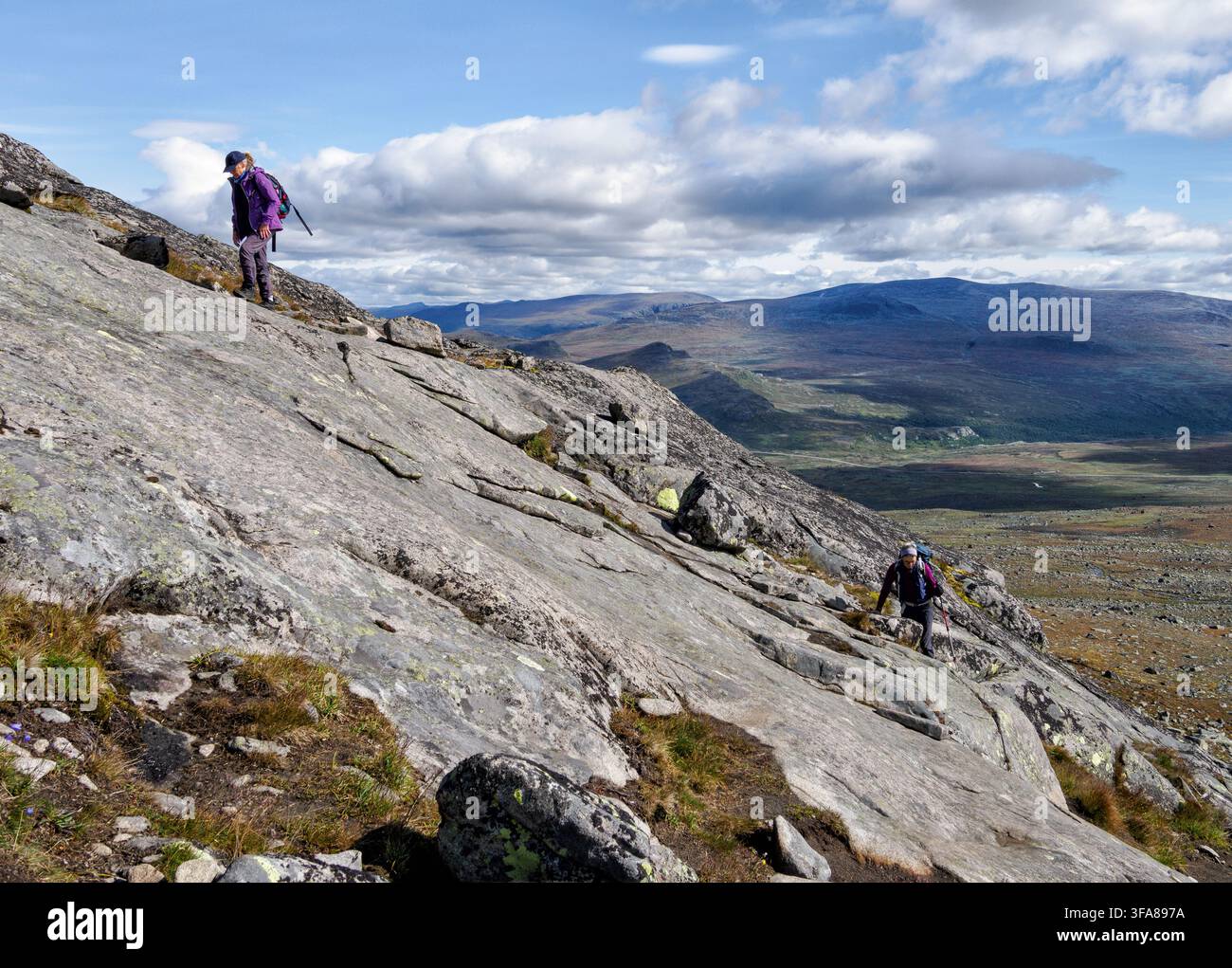 Salita sui pendii cosparsi di rocce del Rasletinden a 2105 m, una delle salite più accessibili del parco nazionale di Jotunheimen nel centro della Norvegia Foto Stock