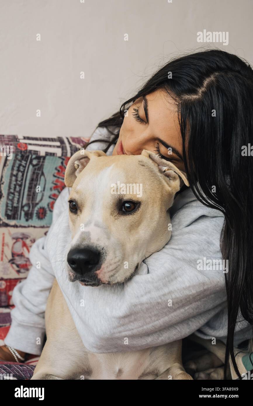 Donna che abbraccia teneramente il suo cane, condividendo un momento di pura affezione e compagnia Foto Stock