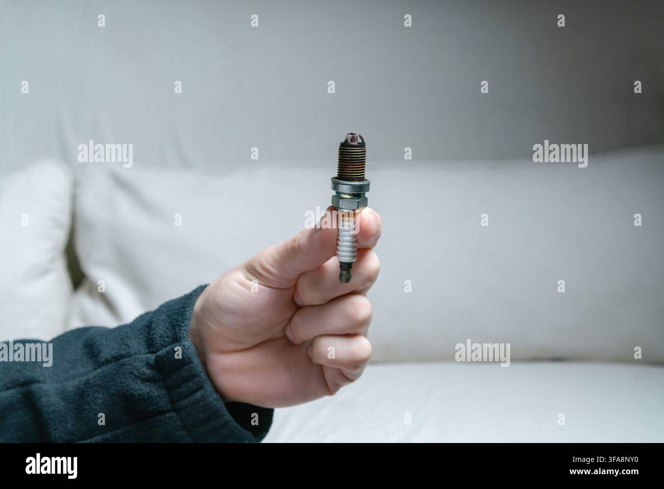 Mano che tiene una spina di controllo a scintilla a tre elettrodi Foto Stock
