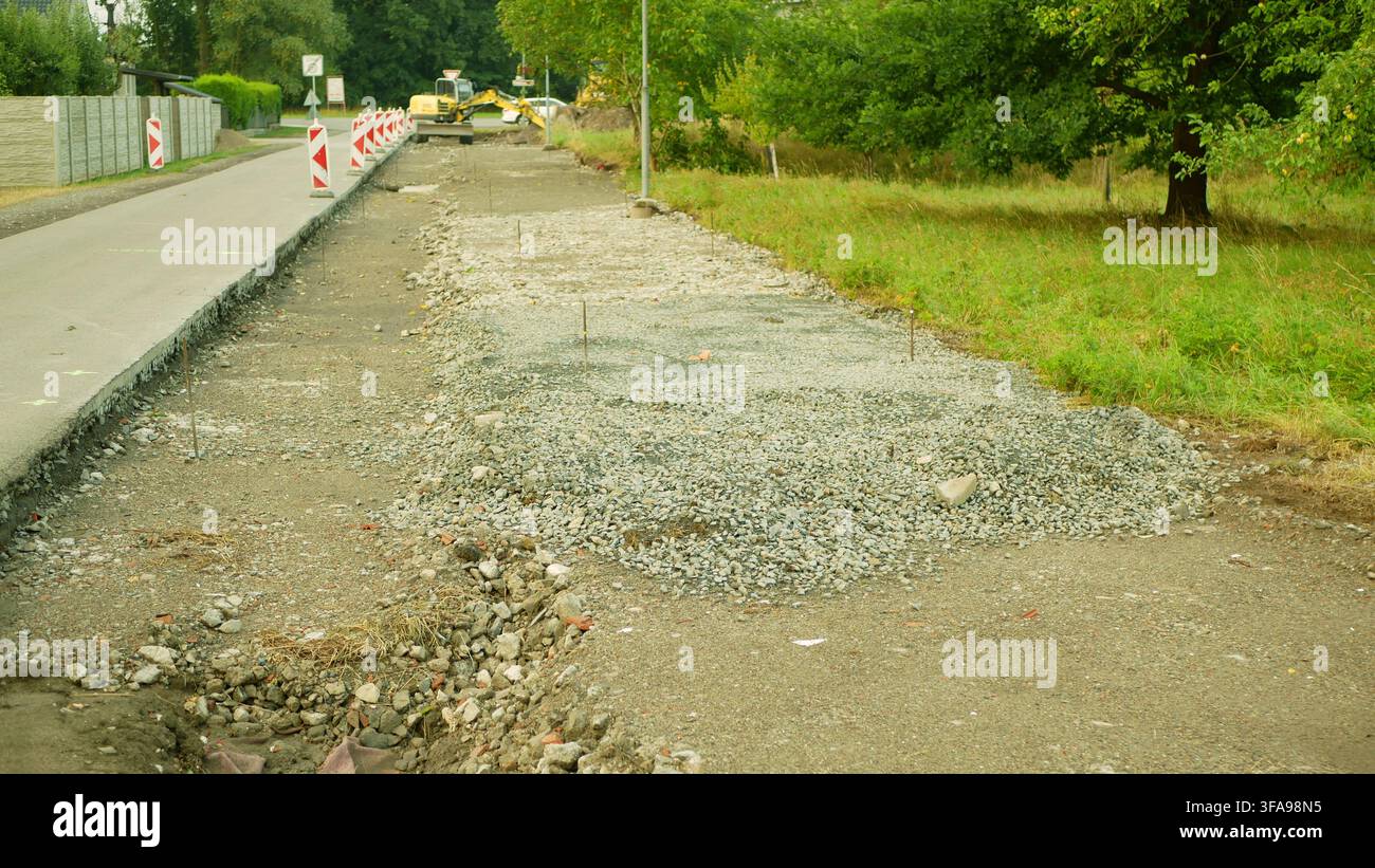 Progetto di miglioramento delle infrastrutture di costruzione stradale ampliamento della carreggiata, costruzione di marciapiedi, miglioramento del drenaggio, ristrutturazione della superficie stradale Foto Stock