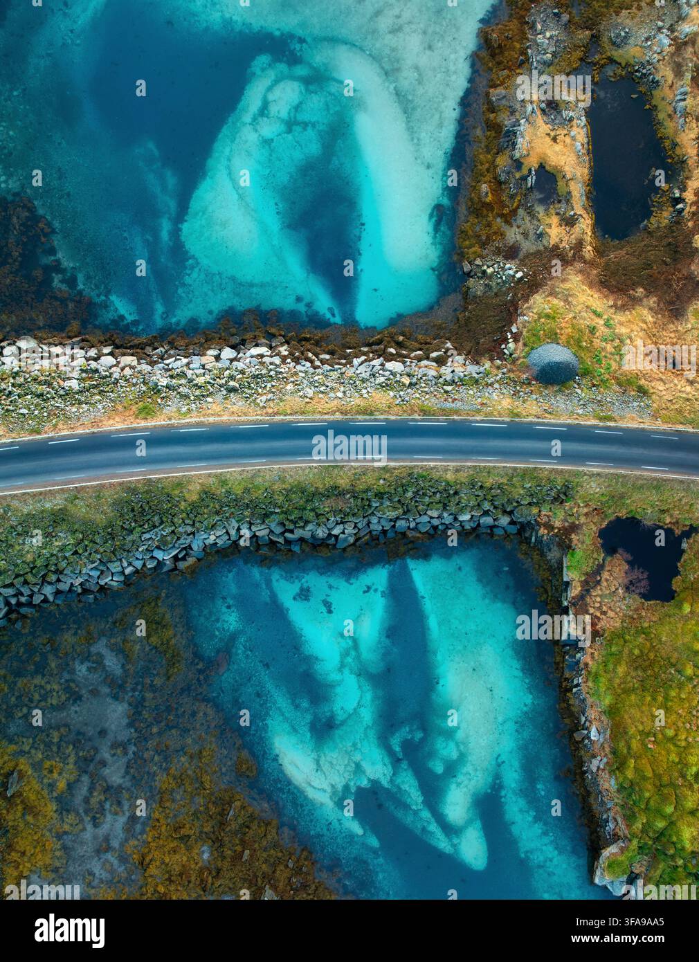 Veduta aerea di una strada asfaltata sopra l'acqua turchese dell'oceano Foto Stock