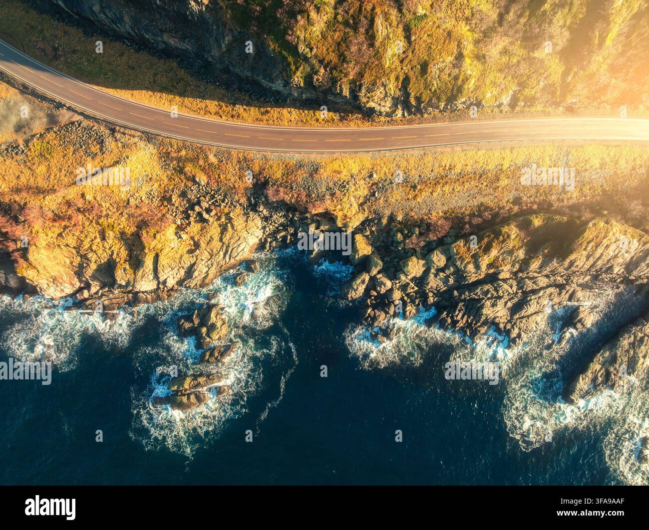 Veduta aerea della strada, costa rocciosa del mare con onde al tramonto Foto Stock