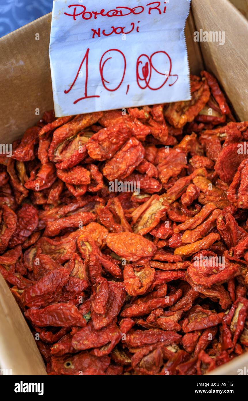 Tipiche pomodori rossi locali essiccati al sole in una scatola con un cartellino del prezzo scritto a mano in mostra su uno stand del mercato contadino a Sanremo, Italia Foto Stock
