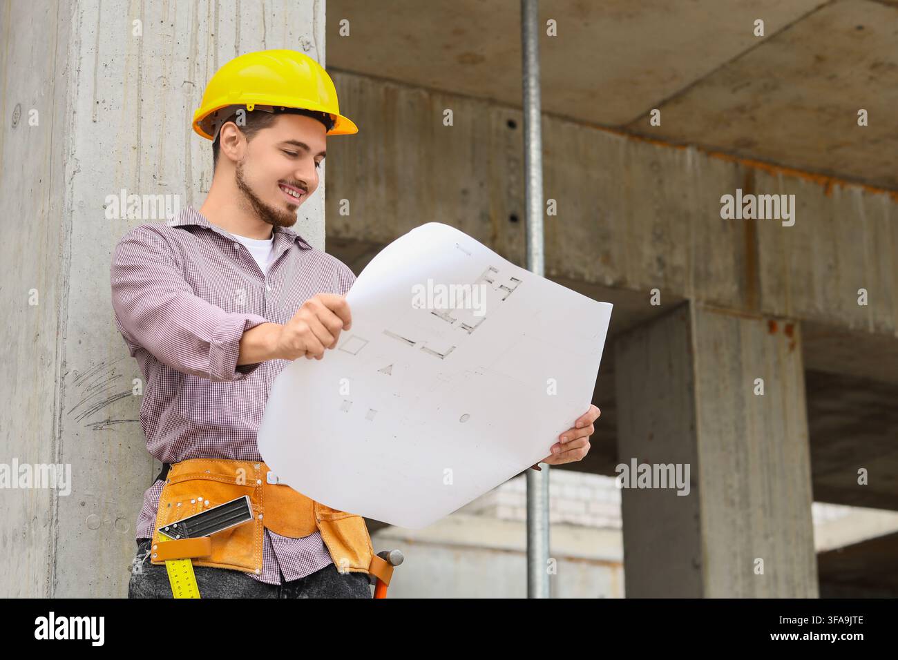 Gestione di progetti edile e ingegneria, architetto o costruttore sorridente che esamina progetti su un cantiere edile Foto Stock