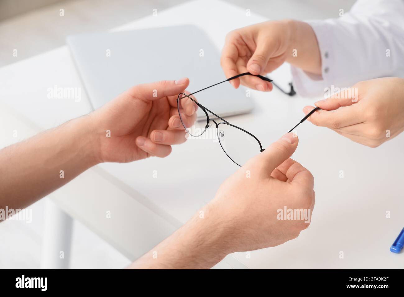 Cura della vista e salute oculare, ottico che consegna occhiali nuovi a un paziente dopo un esame oculistico in clinica Foto Stock