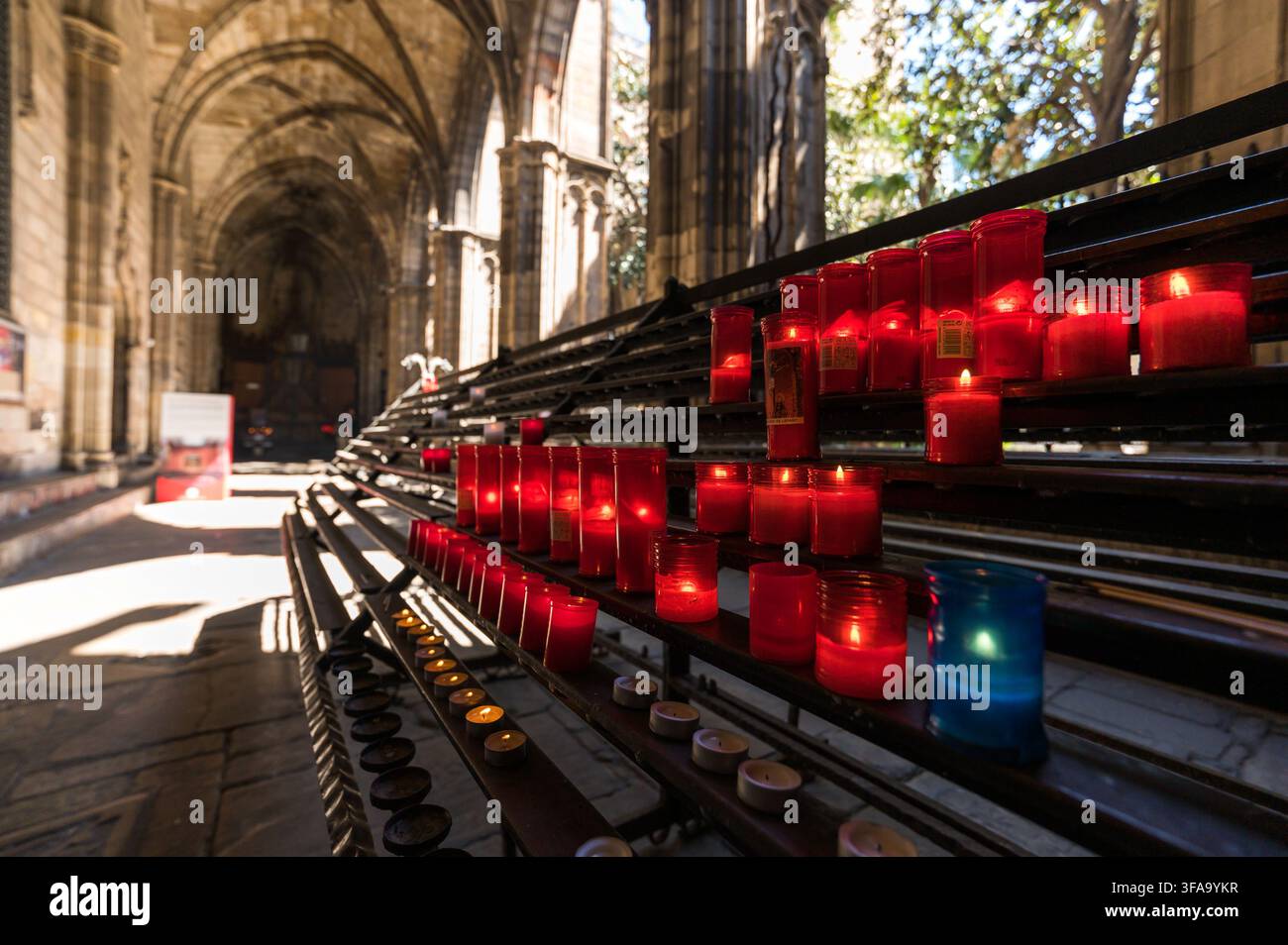 Candele di preghiera rosse ardenti nel cortile interno della Cattedrale di Barcellona Foto Stock