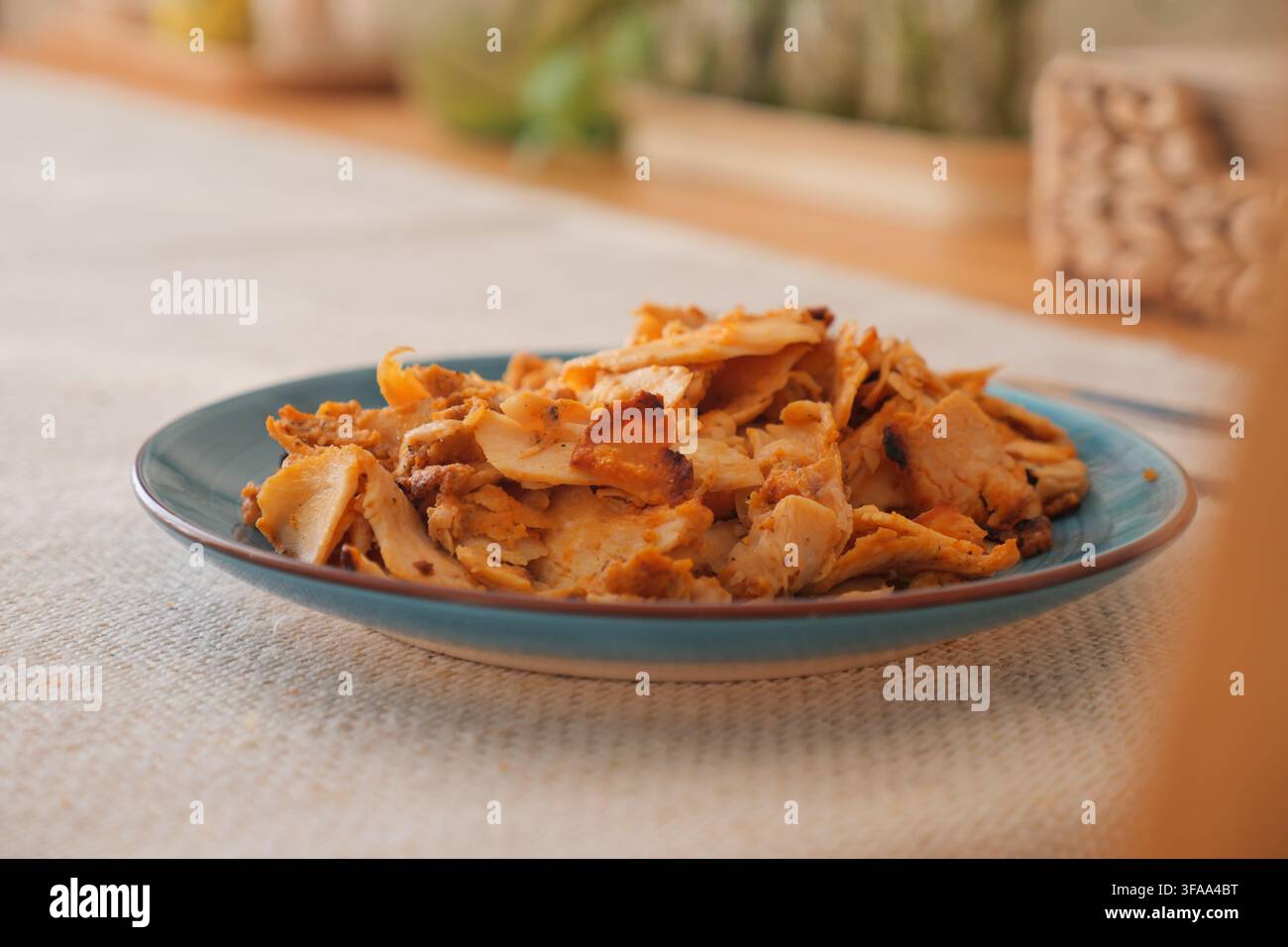 fetta di doner di pollo su un piatto blu posizionato su un tavolo Foto Stock