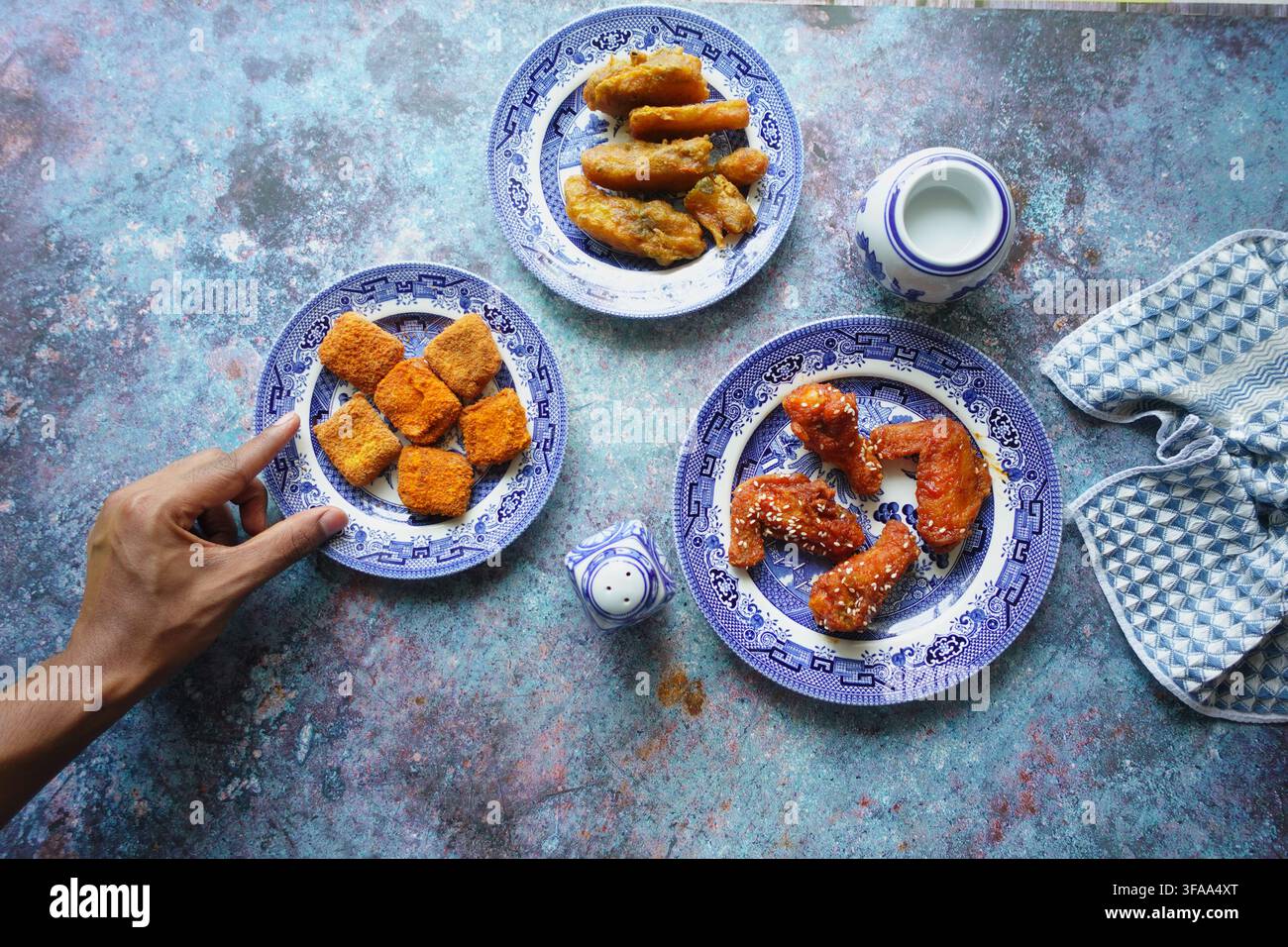 Assaggiare diversi snack su piatti a un tavolo da pranzo Foto Stock