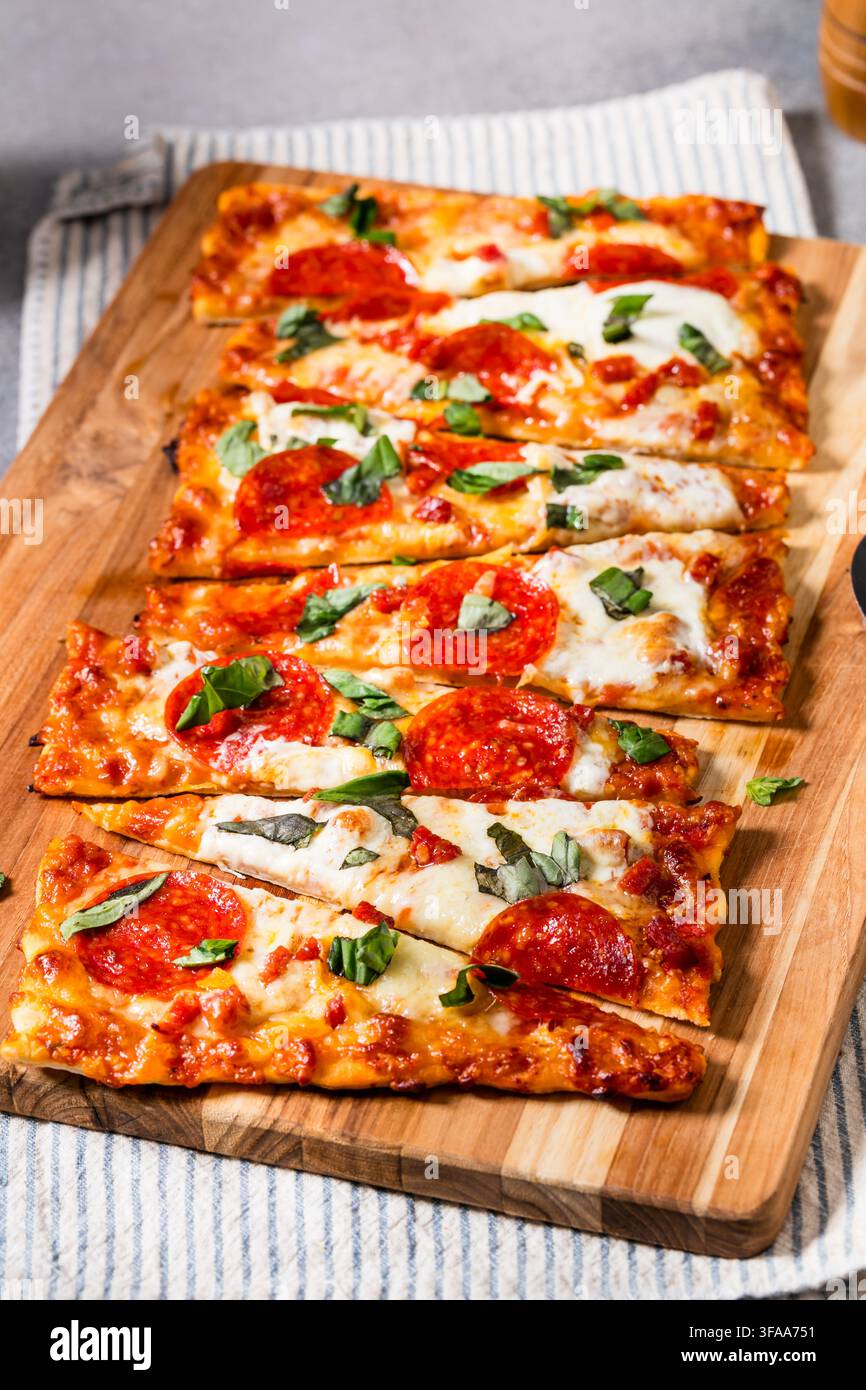 Pizza flatbread fatta in casa saporita con peperoni e basilico Foto Stock