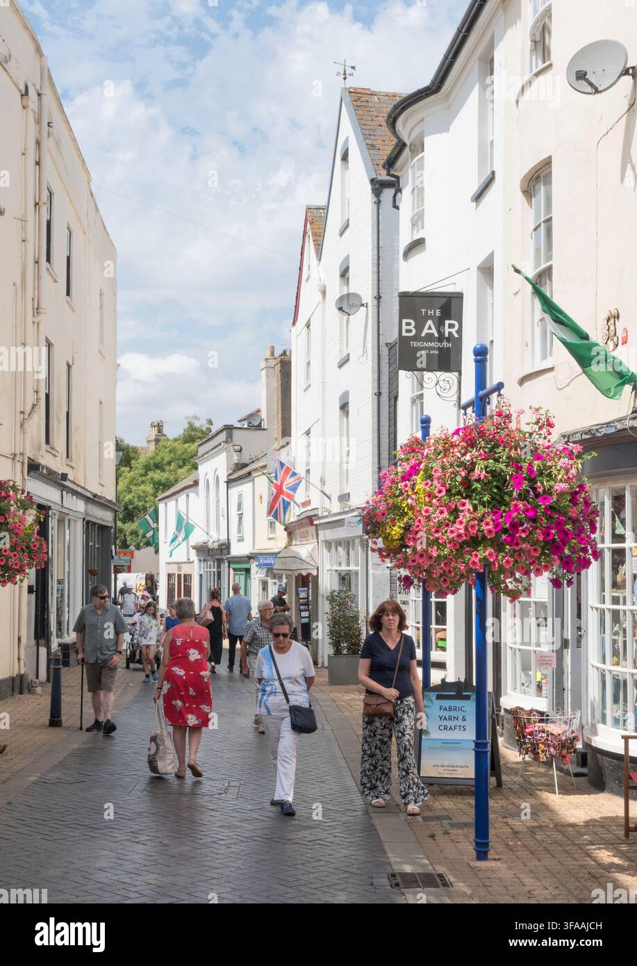 Persone che passeggiano lungo Teign Street a Teignmouth, Devon, Inghilterra, Regno Unito Foto Stock