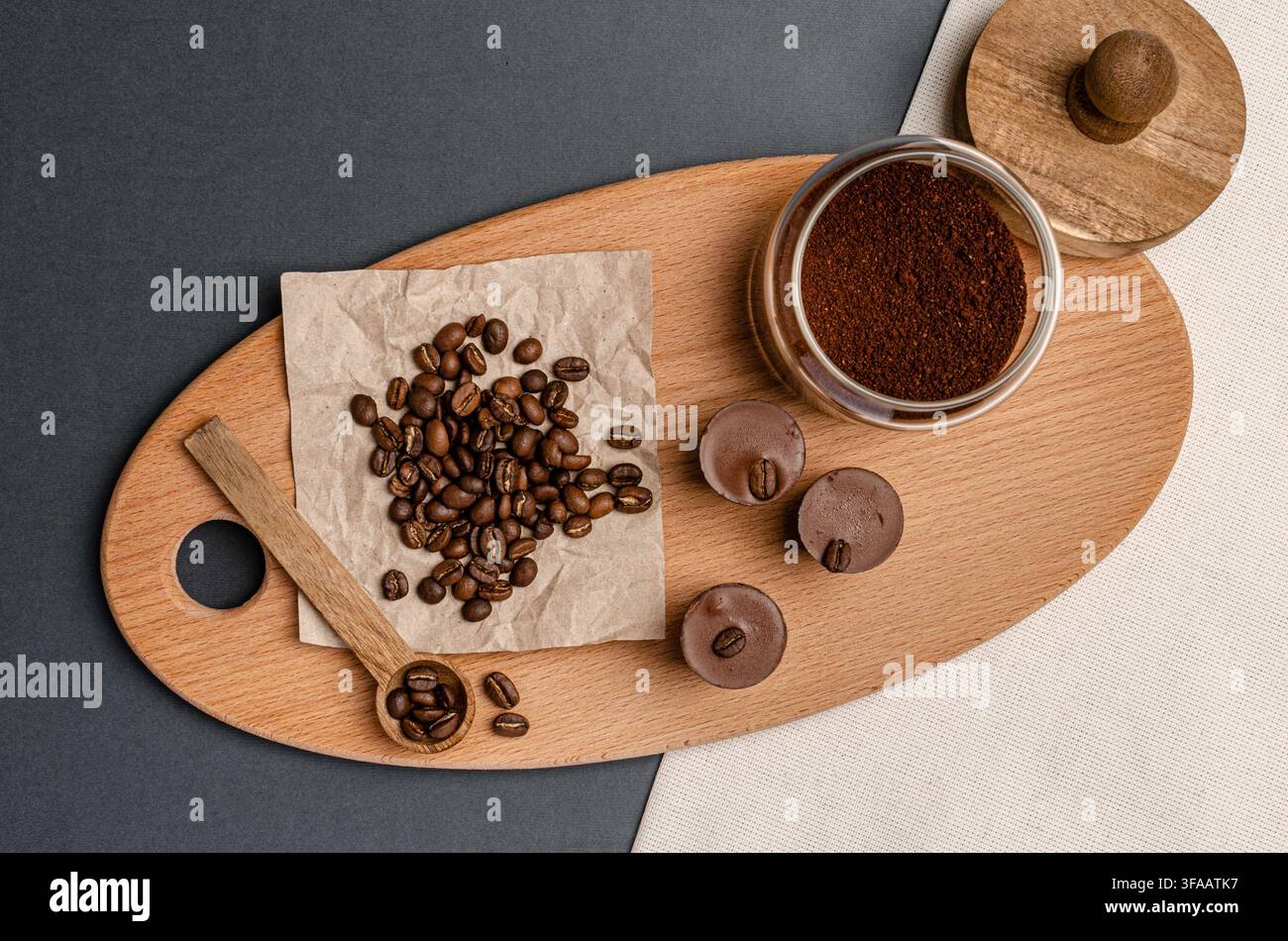 Grani di caffè, caffè macinato e cioccolato su una tavola di servizio in legno, natura morta Foto Stock