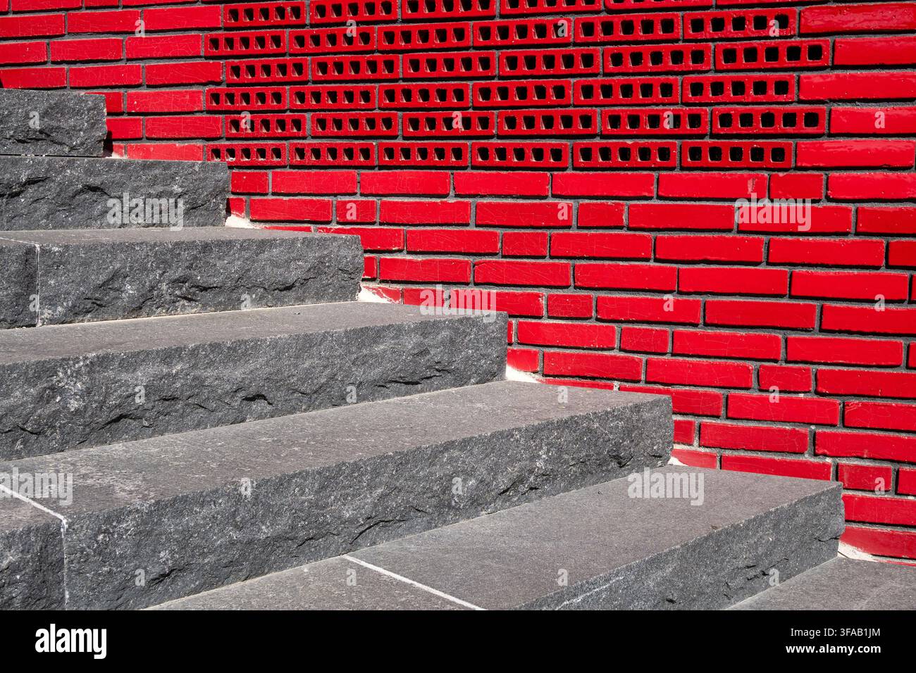 Gradini moderni in granito e muro di piastrelle rosse all'aperto a Stoccolma, Svezia. Foto Stock
