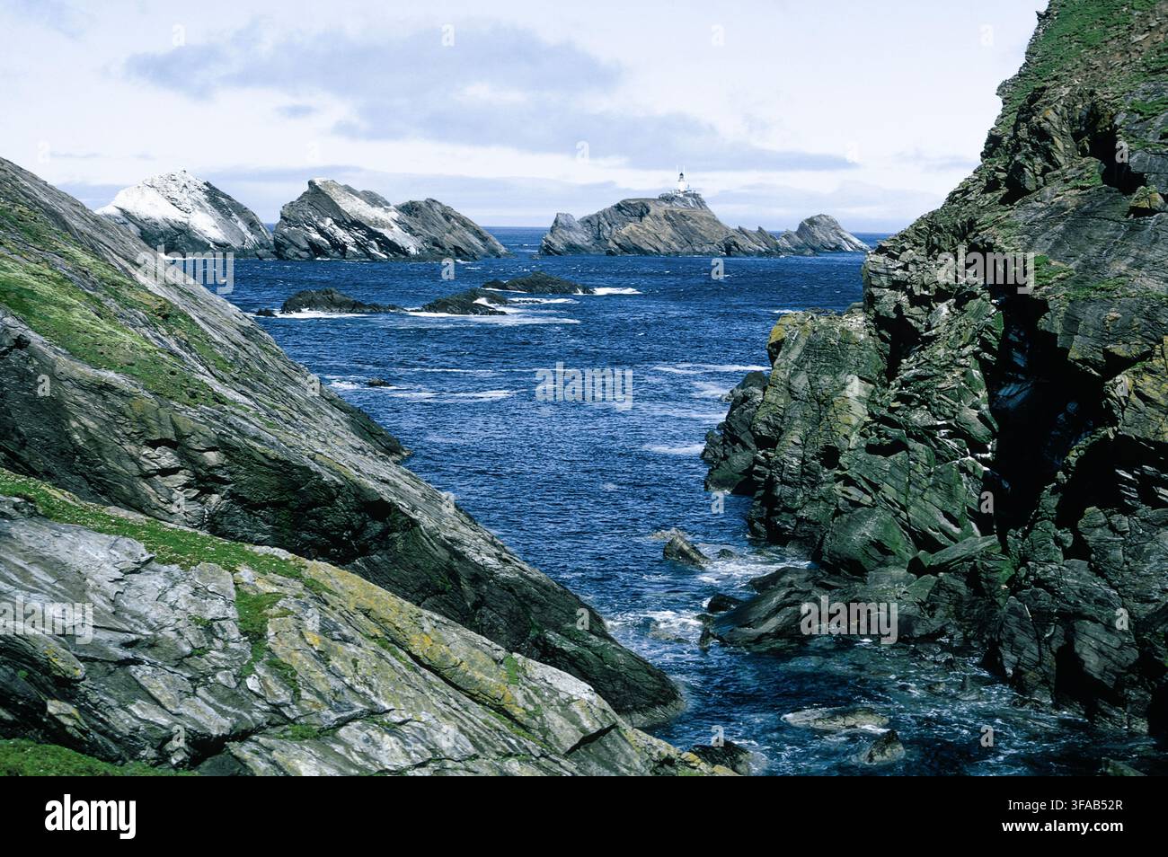Faro di Muckle Flugga e scogliere frastagliate da Hermaness, Unst, Isole Shetland, Scozia. Foto Stock