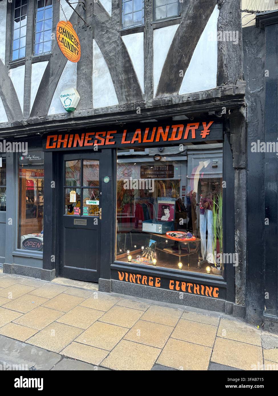 YORK, REGNO UNITO - MARZO 2024: La vetrina di Chinese Laundry, un negozio di abbigliamento vintage ospitato in un edificio storico in stile a graticcio a York. - Immagine stock catturata con smartphone