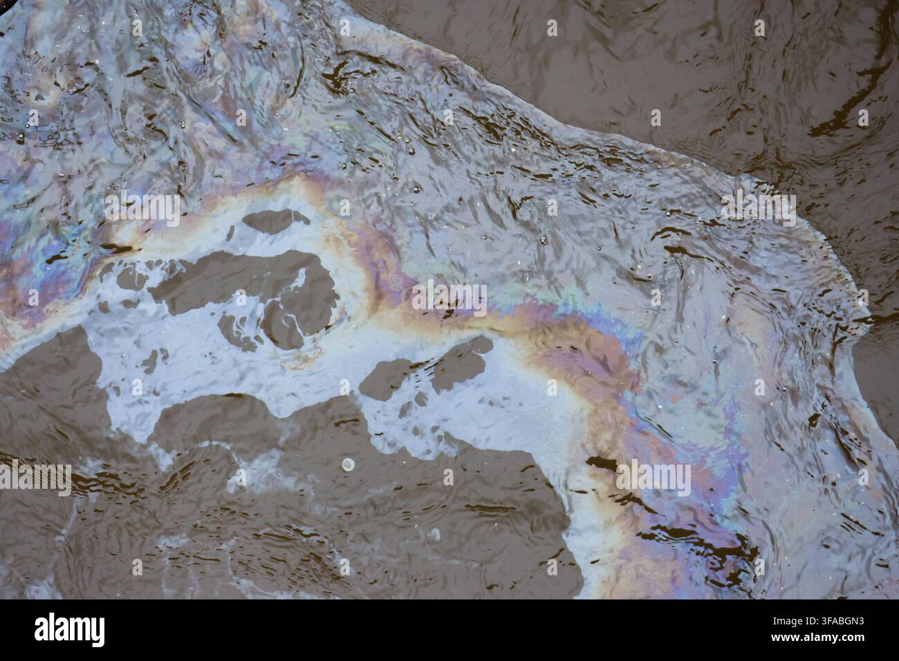 Un paesaggio aereo astratto con terreno ghiacciato, texture minerale colorata e schemi d'acqua irregolari che creano una superficie geologica naturale con colori smorzati Foto Stock