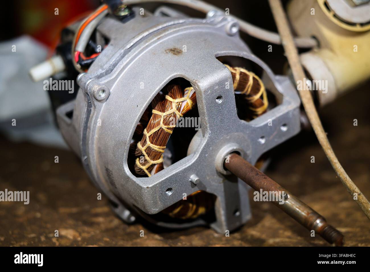 Uno stator di motore a induzione elettrico con avvolgimento in rame, involucro metallico, officina di riparazione di motori elettrici con avvolgimento dello stator in rame esposto e metallo Foto Stock
