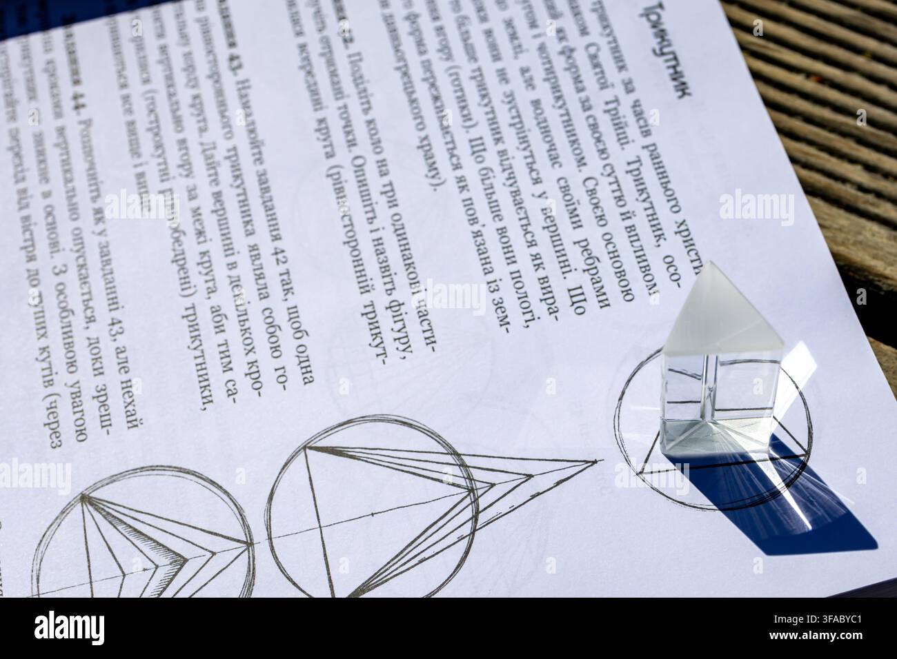 Moneta con simbolo di Pi appoggiata su un libro di matematica aperto sopra linee di cerchi intersecanti e punti etichettati alla luce del sole che rappresentano la teoria dei numeri, la geometria e la cultura, a Foto Stock