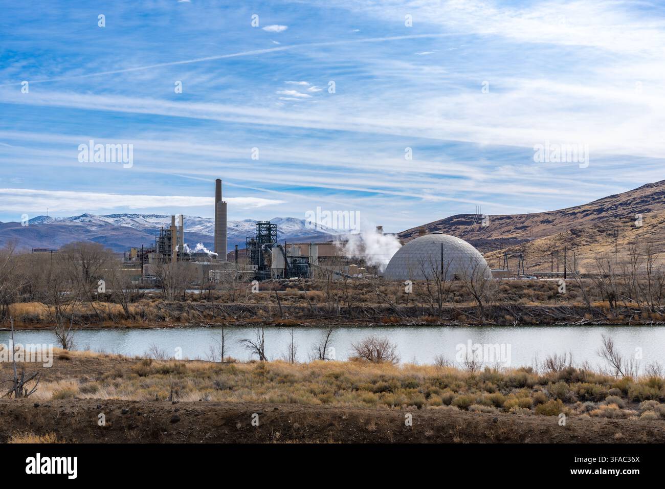 Vapore che si alza in una grande centrale elettrica a carbone con deposito di carbone a cupola e alti camini nel deserto del Nevada. Foto Stock
