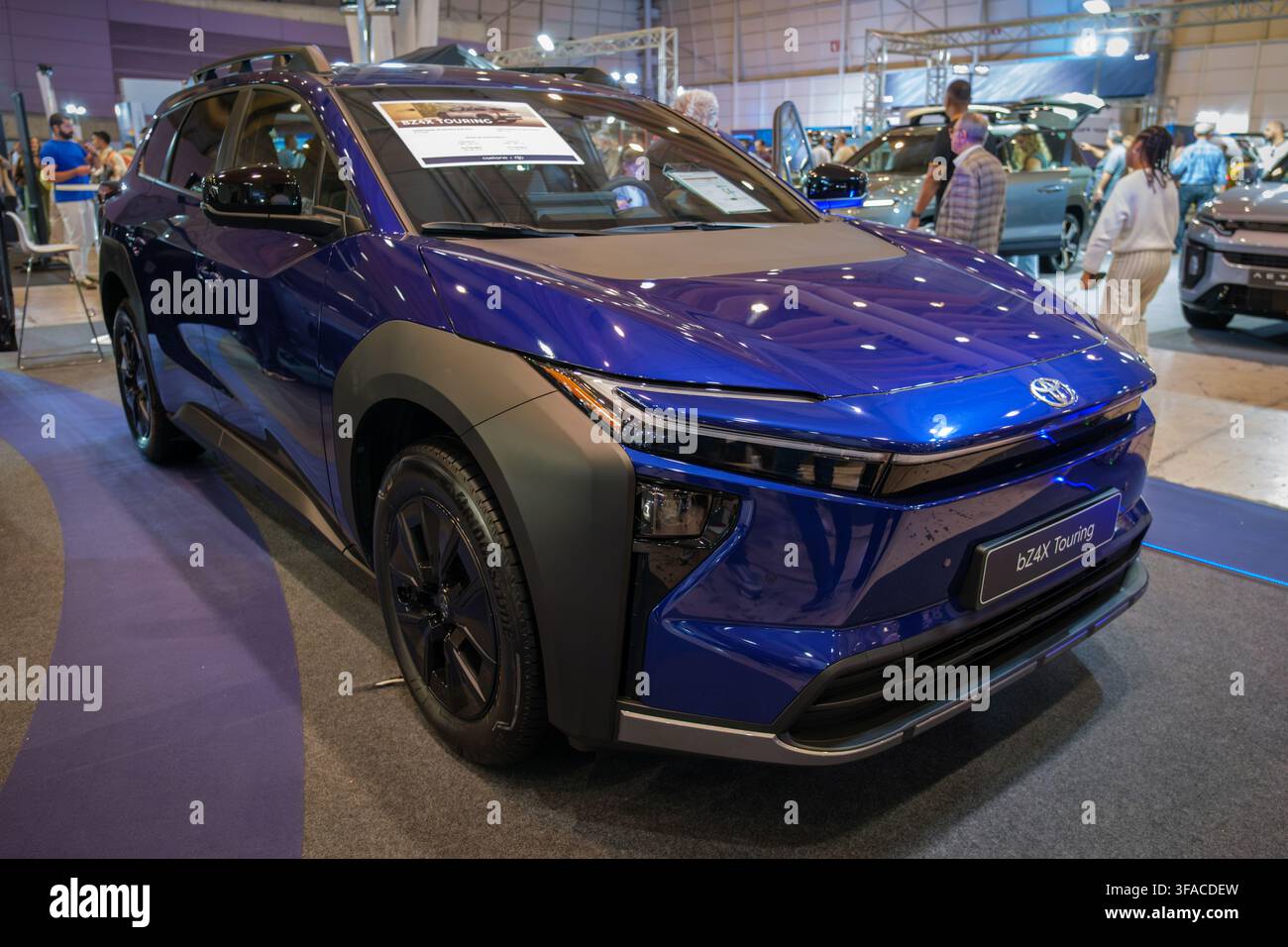 Lisbona, Portogallo - 16 maggio 2026: SUV elettrico blu Toyota bZ4X Touring esposto al salone automobilistico ECAR Show, con visitatori e cartello dell'evento visibile Foto Stock
