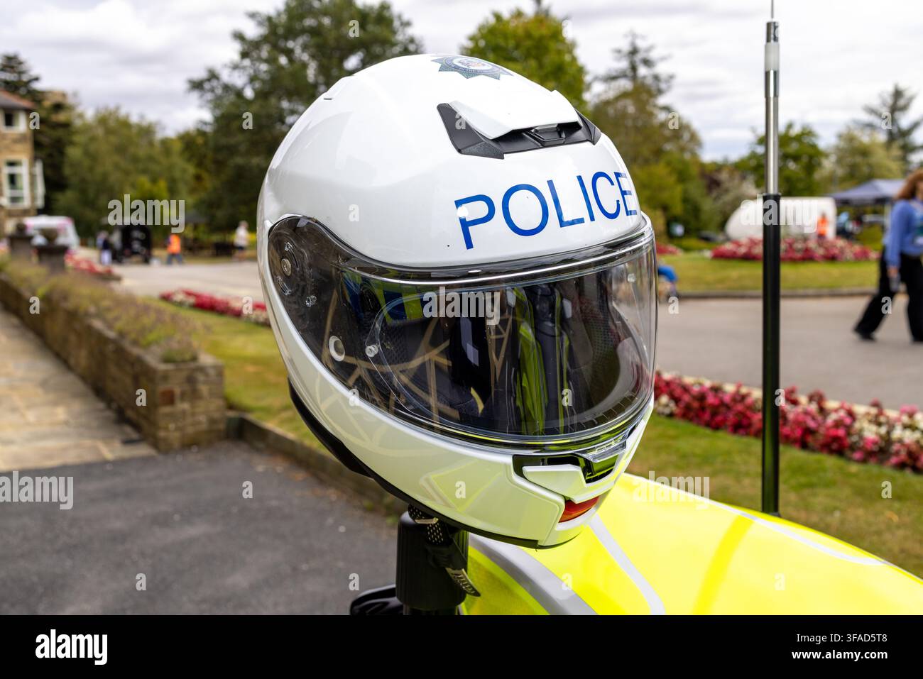 Close up di un casco da motociclista bianco della polizia con visiera trasparente e scritta blu POLIZEI esposta sopra una carrozzeria riflettente ad alta visibilità con poliziotto Foto Stock