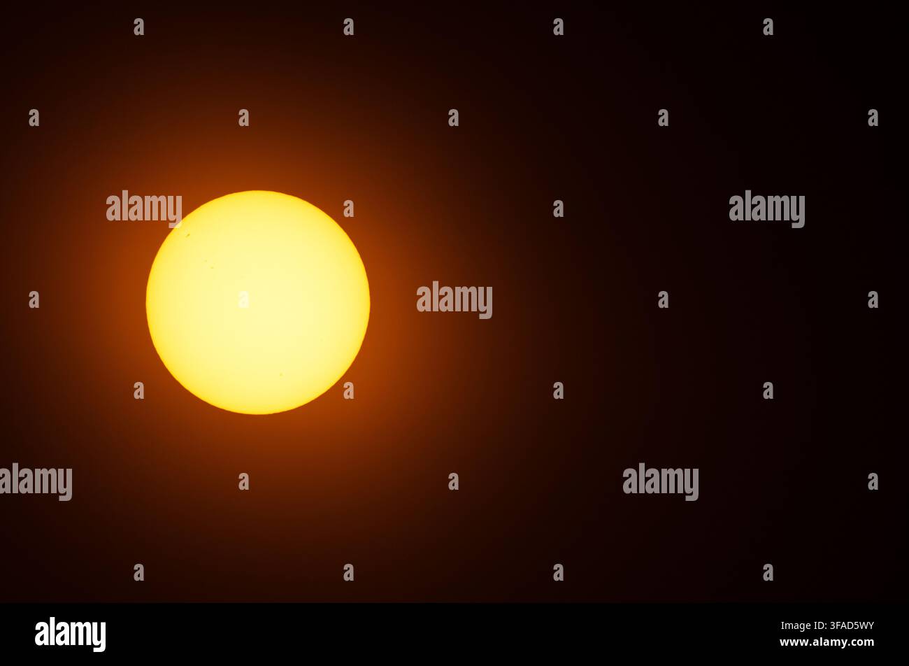 Il sole, ripreso attraverso un filtro solare; ore 18.00. Spazio per la copia a destra, sfondo nero. La nostra stella più vicina. Foto Stock