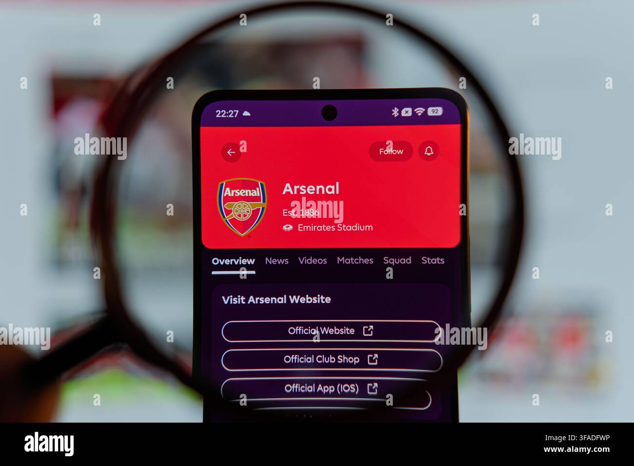 Pagina del profilo dell'Arsenal Football Club visualizzata sullo schermo dello smartphone sotto una lente d'ingrandimento, club di calcio della Premier League inglese e digitale sportivo Foto Stock
