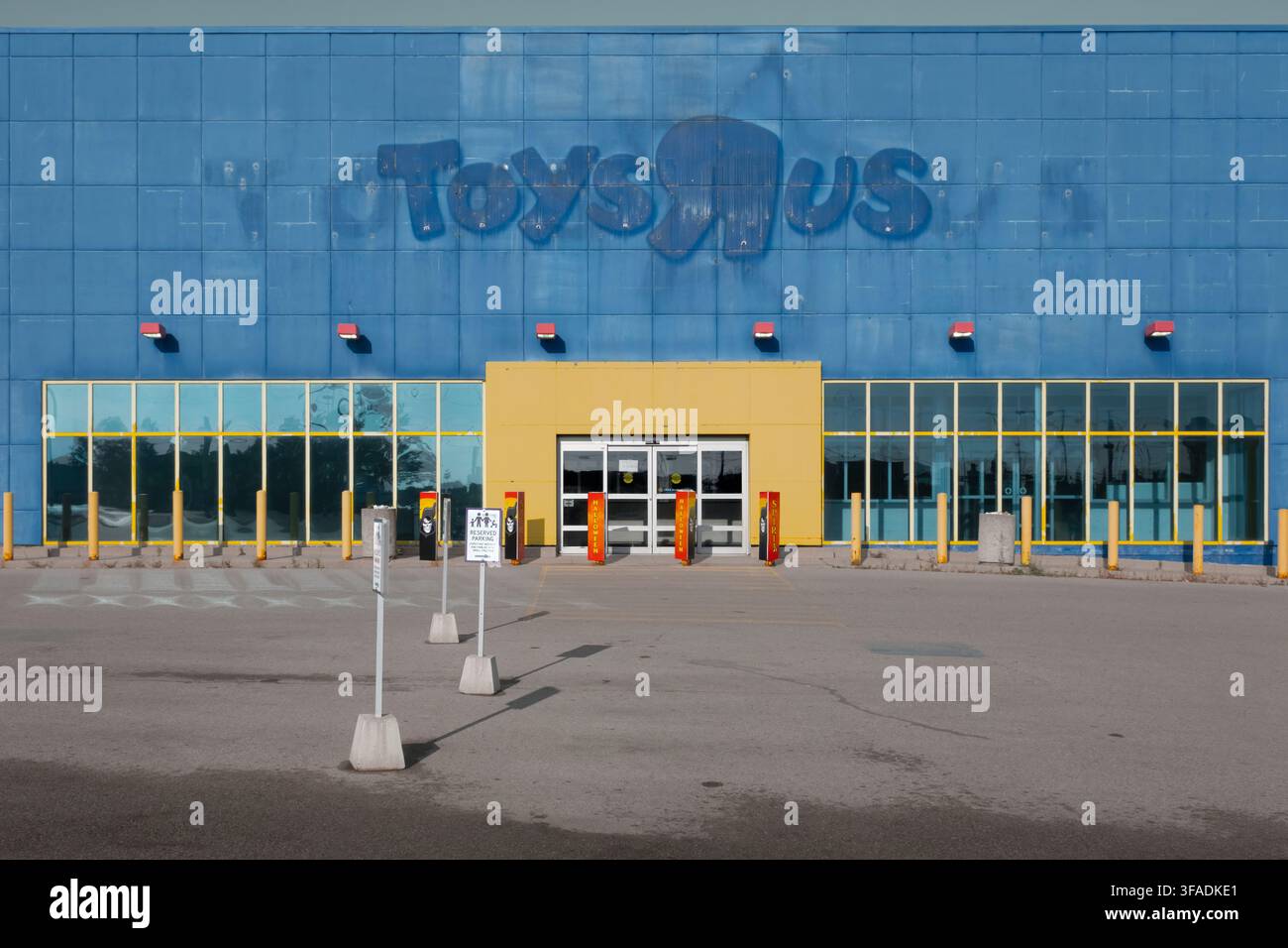 ex grande distribuzione Toys R Us chiusa con cartelloni sbiaditi, pubblicità stagionale di Halloween e un parcheggio vuoto Foto Stock