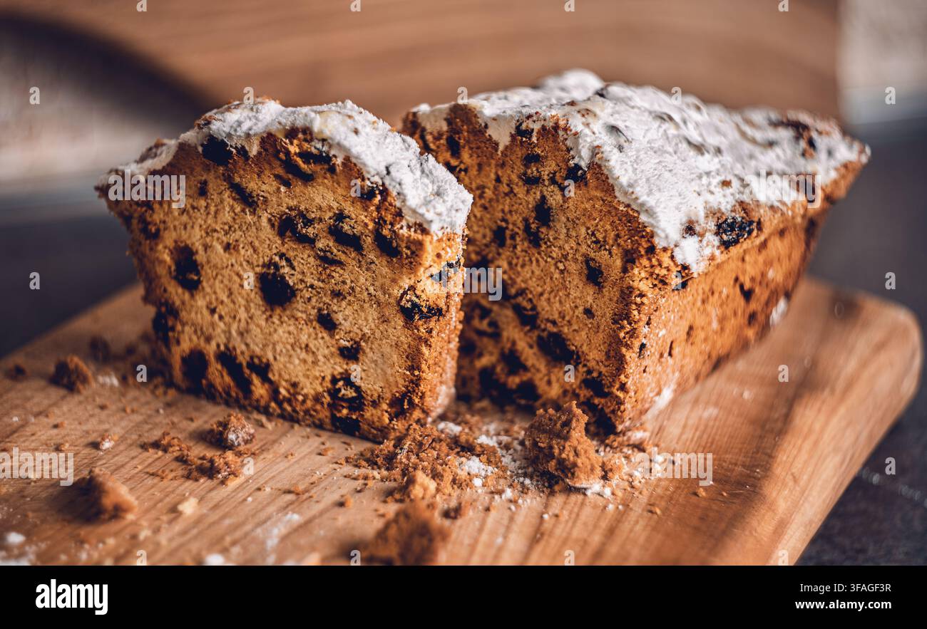 Torta margherita con gocce di cioccolato spolverata di zucchero a velo su una tavola di legno con briciole Foto Stock