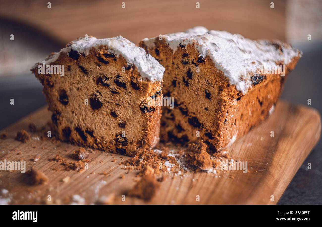 Torta con gocce di cioccolato appena sfornata ricoperta di zucchero a velo che mostra una ricca consistenza delle briciole Foto Stock