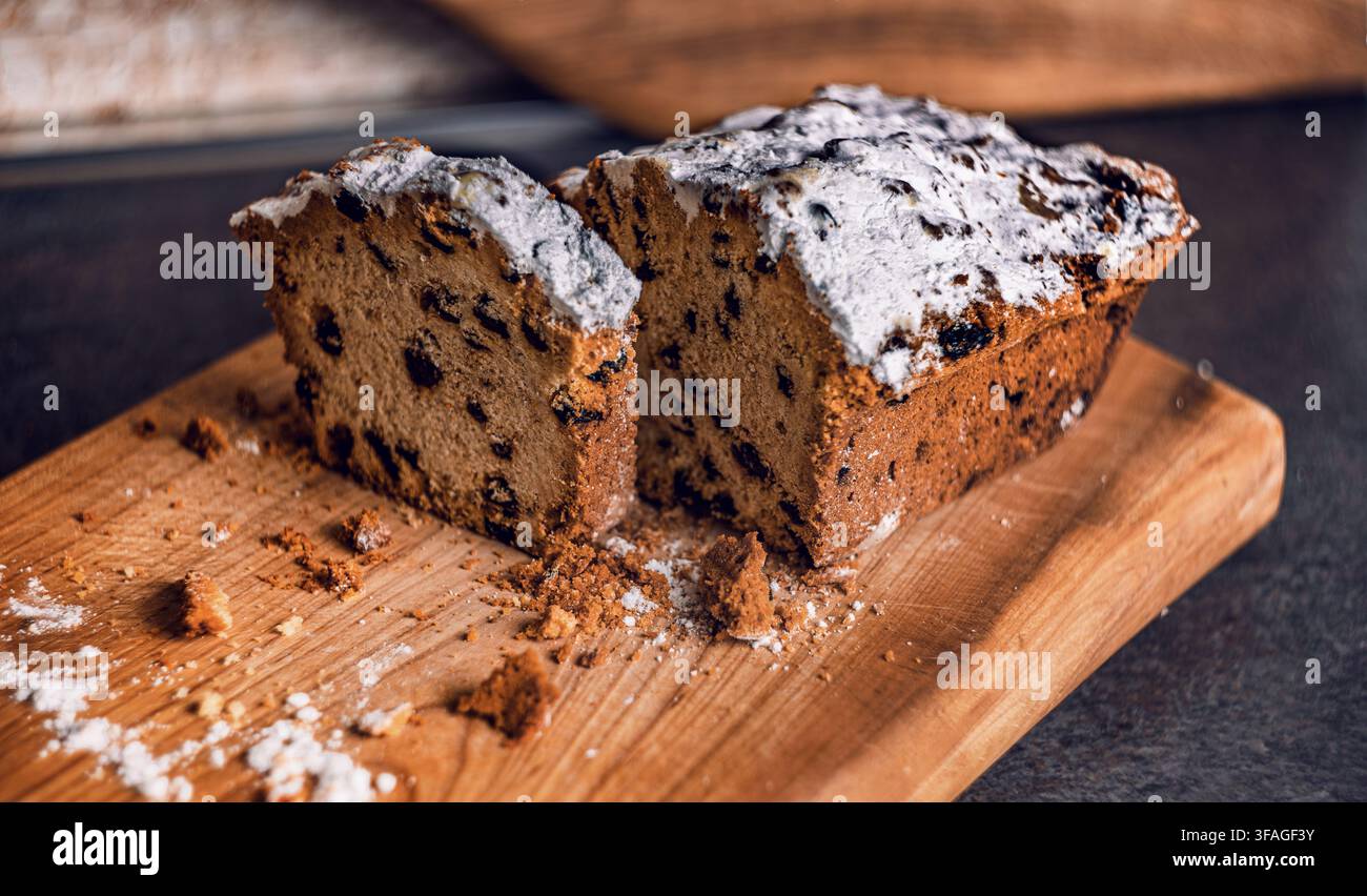 Pound cake fatto in casa con gocce di cioccolato e guarnizione di zucchero a velo affettato su un legno Foto Stock