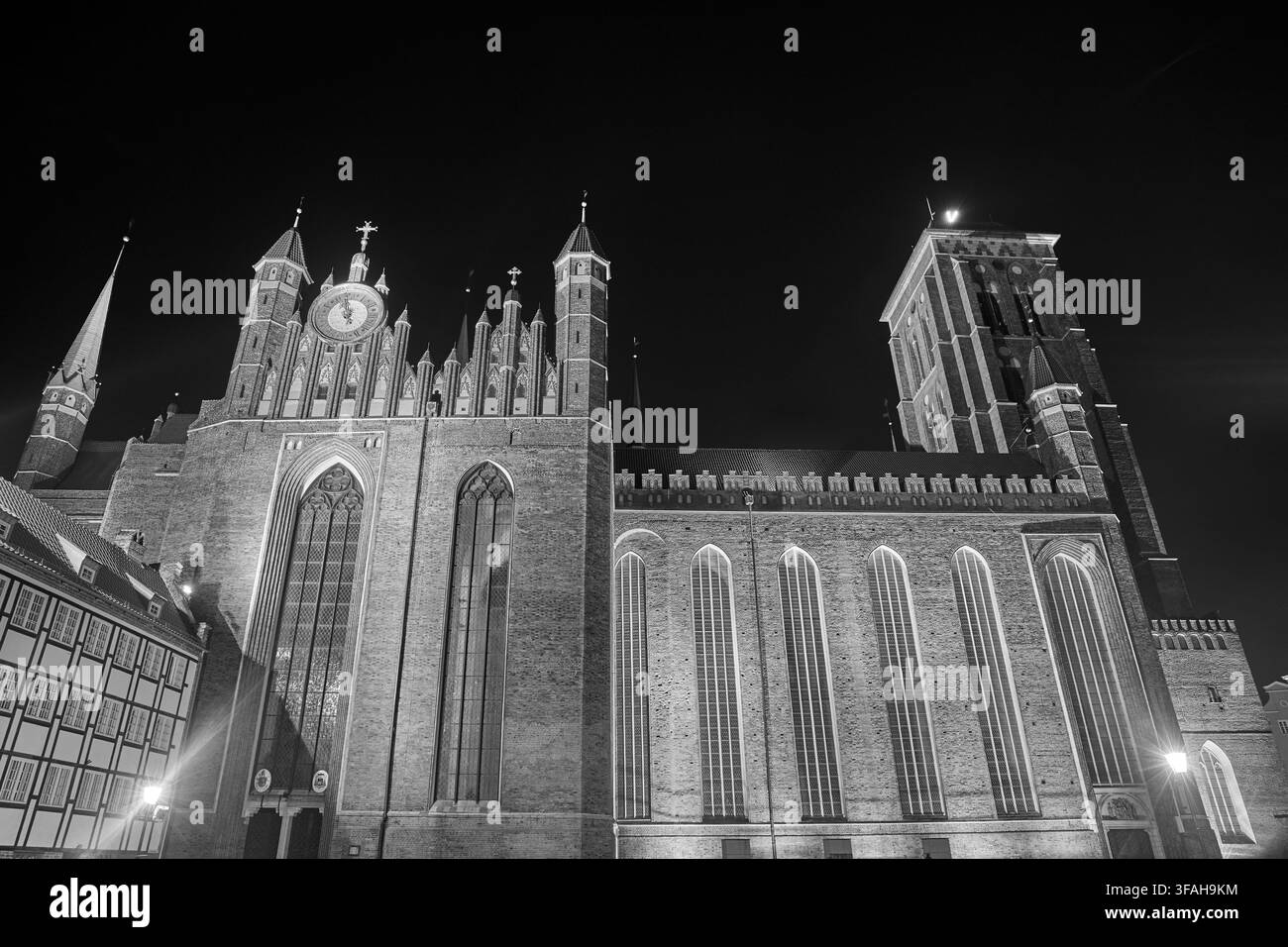 Basilica co-cattedrale gotica in mattoni dell'Assunzione della Beata Vergine Maria a Danzica, illuminata di notte, Polonia, monocromo Foto Stock