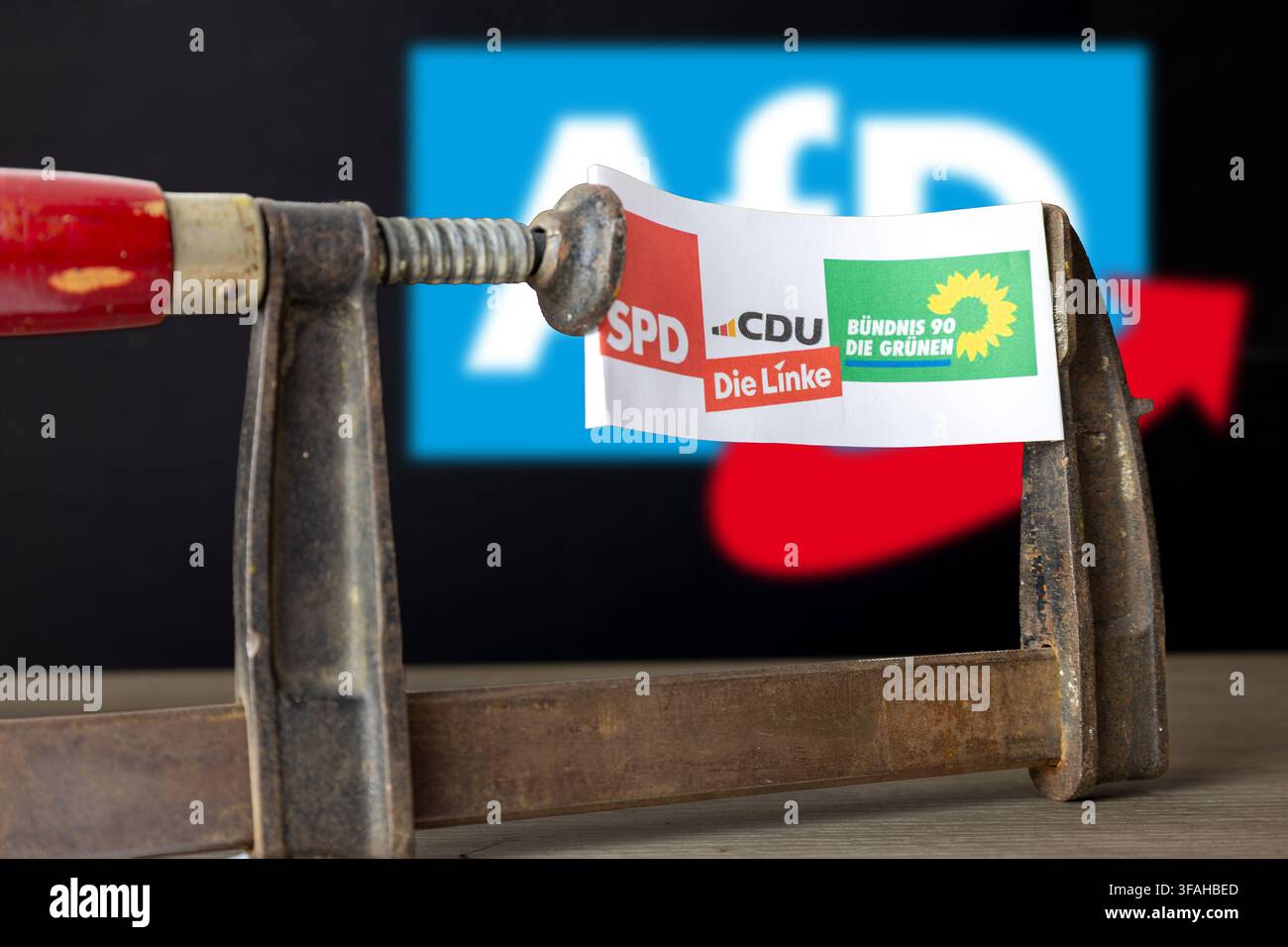 (Fotomontaggio) Immagine illustrativa: Un foglio con i loghi della CDU, SPD, dei Verdi e di Die Linke in una morsa a vite, con il logo AfD nella Ba Foto Stock