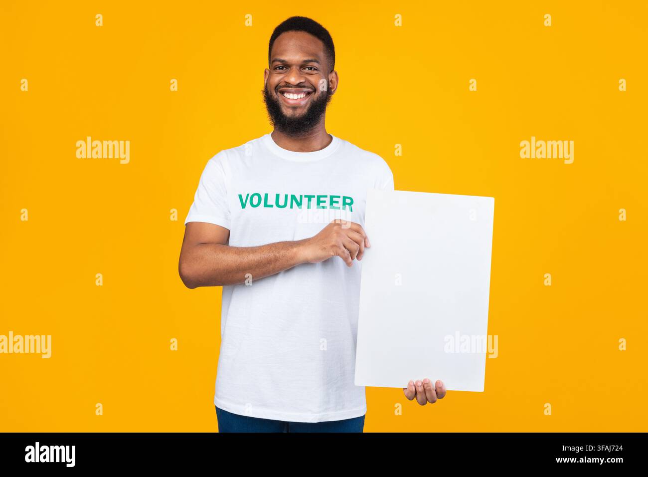 African Volontario uomo che mostra bianco bordo sopra sfondo giallo Foto Stock