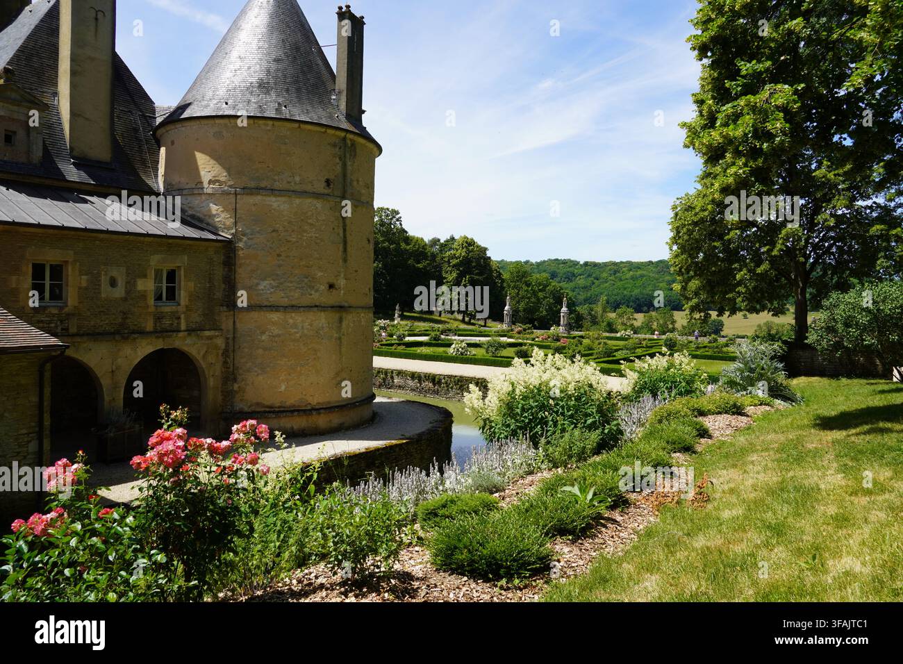 Castello di Bussy-Rabutin, Castello di Bussy-le-Grand. Fossa. Giardino con fiori. Un castello nel dipartimento della Côte-d'Or, Borgogna, Francia. Giugno. Foto Stock