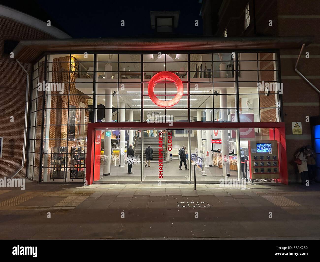 LONDRA, REGNO UNITO - 18 GENNAIO 2023: L'ingresso illuminato del teatro del Globe di Shakespeare sulla South Bank a Londra di notte. - Immagine stock catturata con smartphone