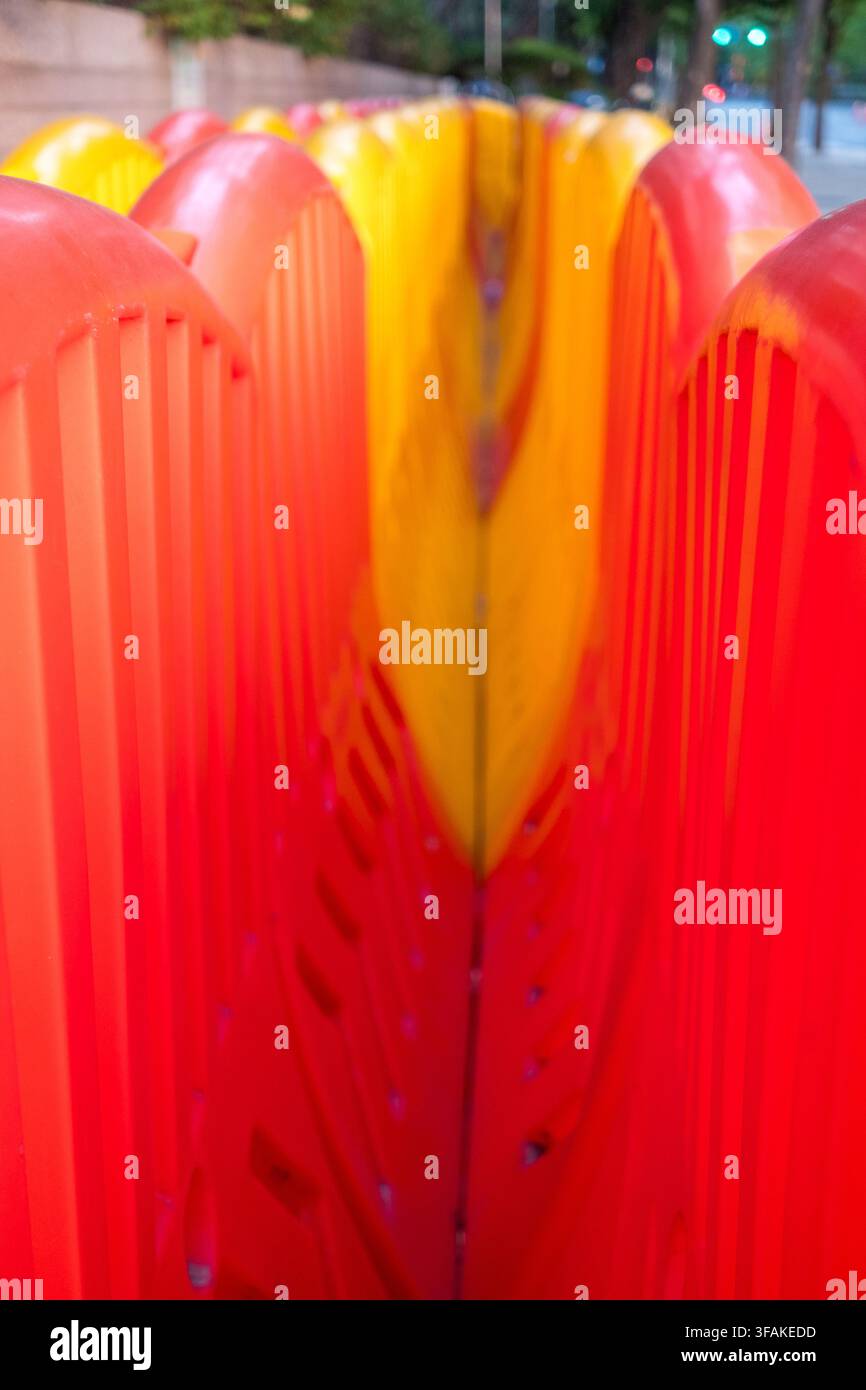 Barriere di plastica dai colori vivaci con texture a costole spesse e sezioni continue rosse e gialle nella strada Foto Stock