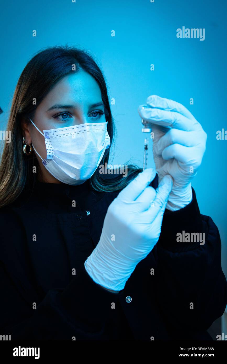 Medica che riempie una siringa con medicinali Foto Stock